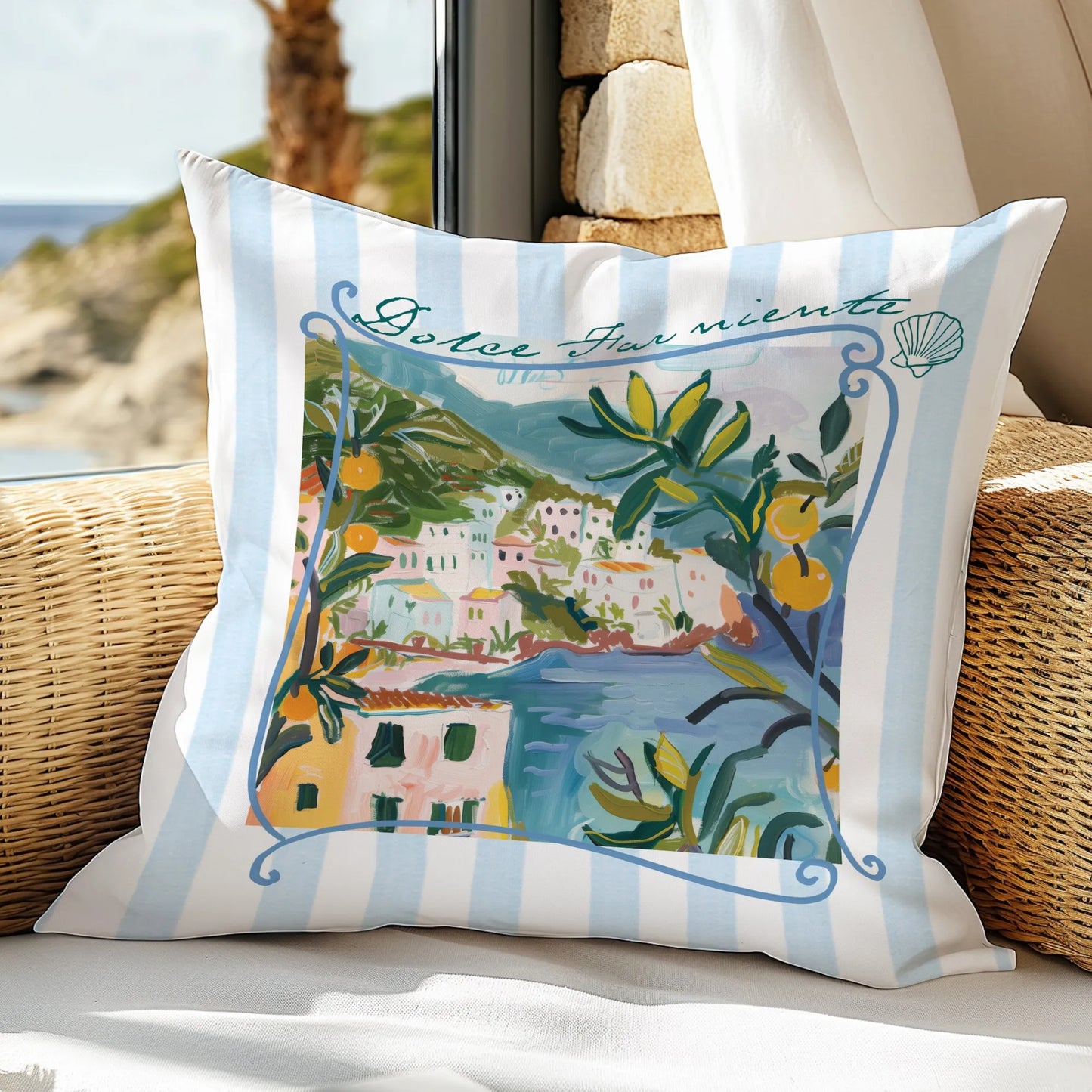 Blue striped “Dolce Far Niente” lemon pillow on rattan chair by a window with beach view.
