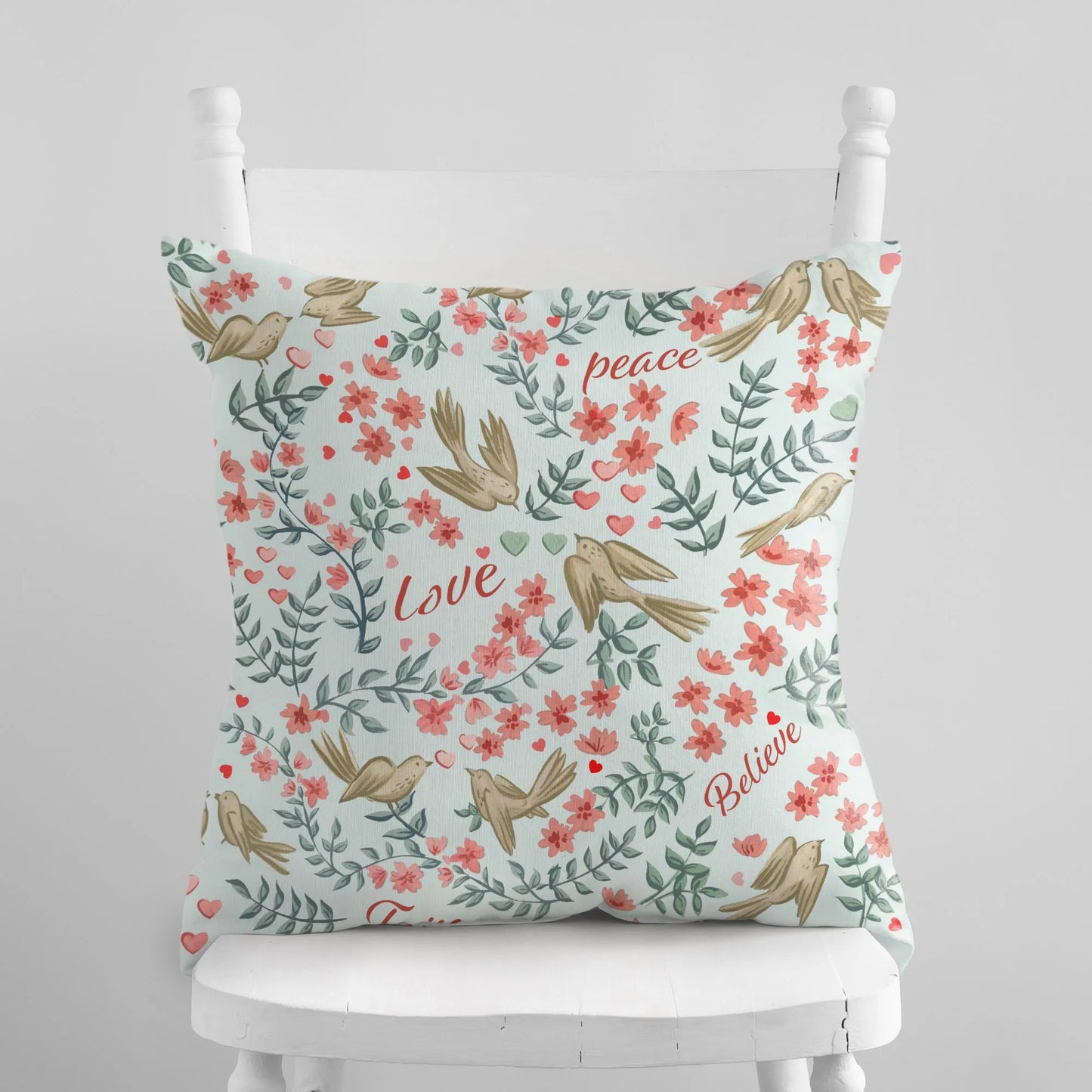 "Hope Peace Love Believe" Love Birds Valentine Pillow Cover with bird and floral pattern on a white chair, Blue Water Songs brand.