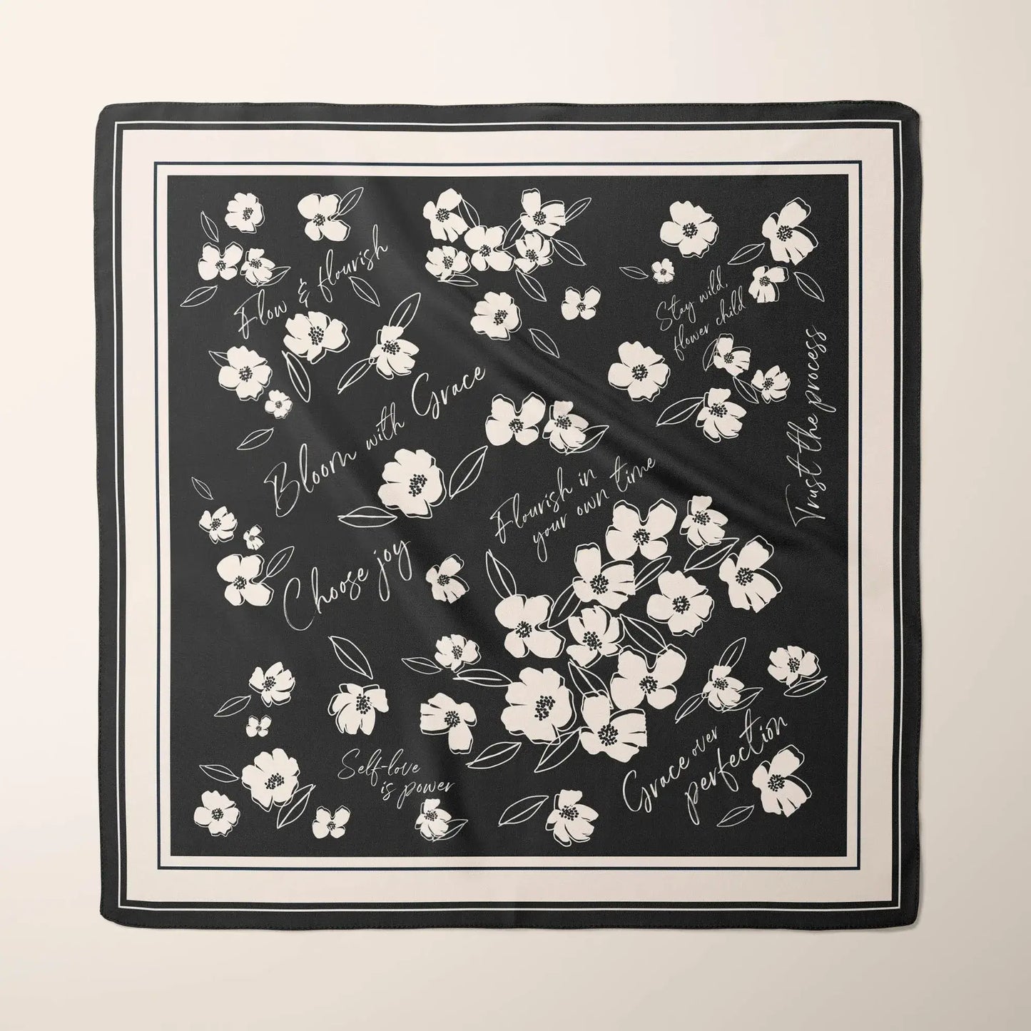 Black silk scarf with white minimalist wildflowers and inspirational phrases like "Bloom with Grace" and "Choose joy".