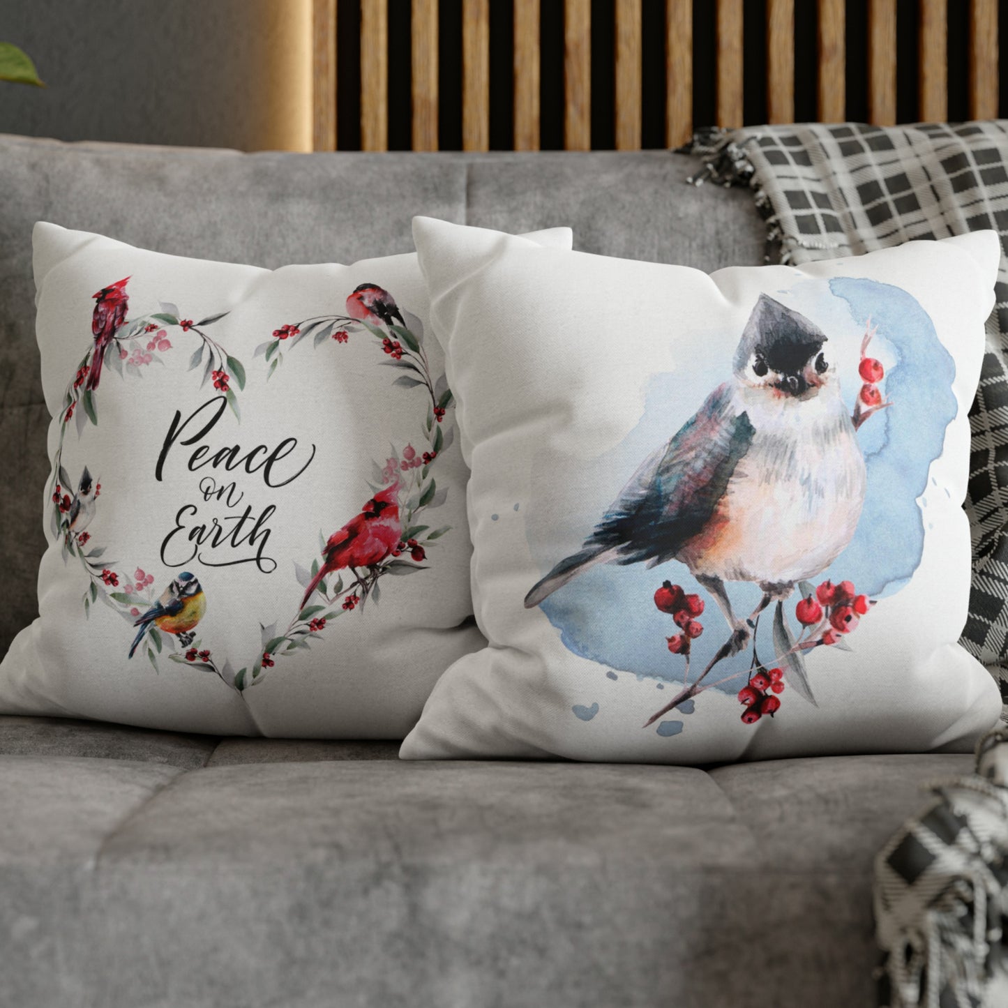 Winter bird and Peace on Earth pillows on gray couch – watercolor Christmas pillows with red berries and wreath design
