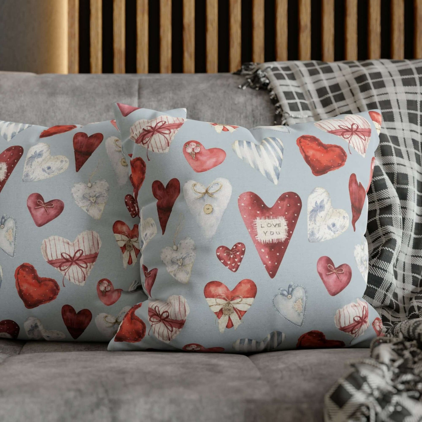 Vintage hearts Valentine pillows on bed, showing red and blue watercolor hearts on soft blue background