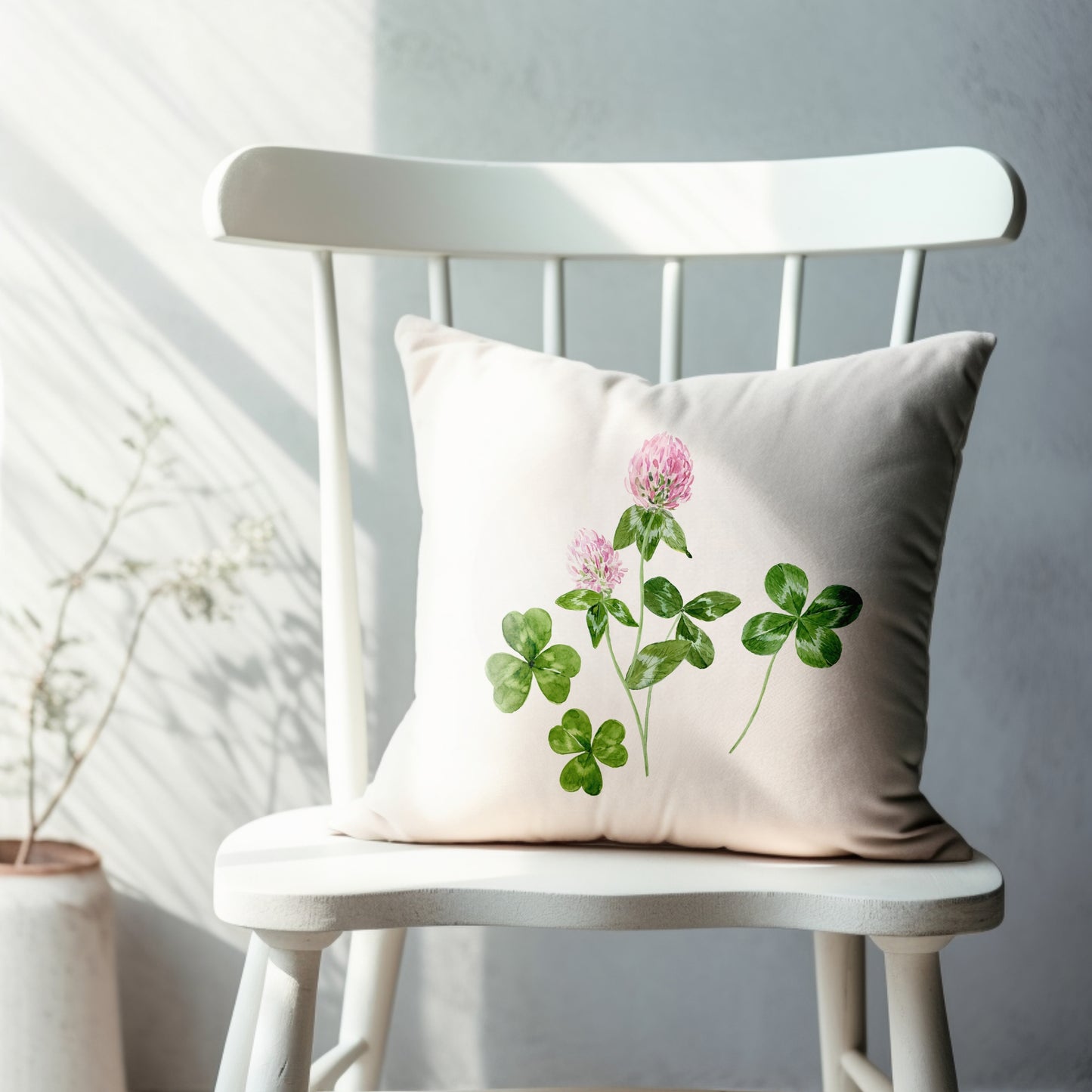 a white chair with a pillow with a pink flower on it