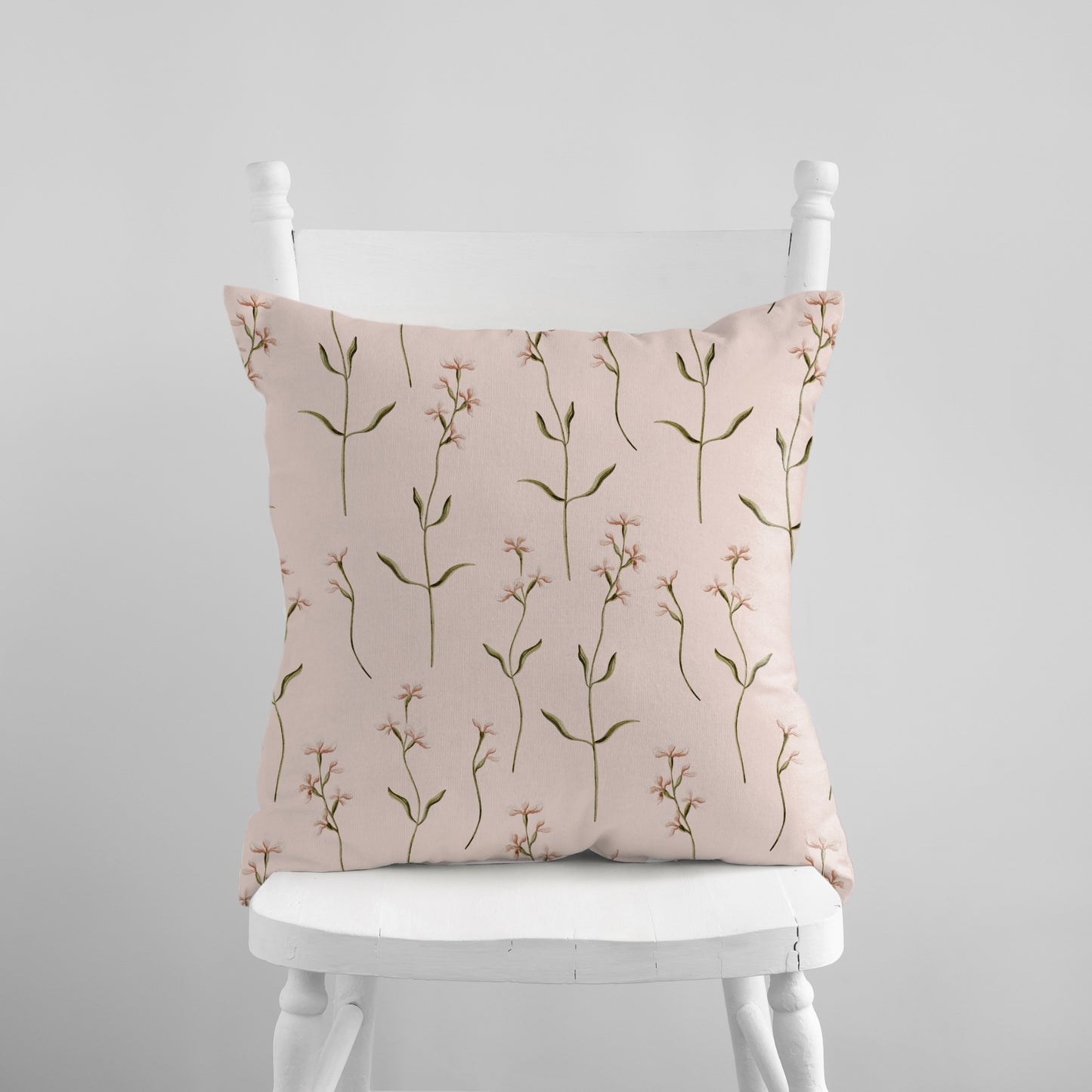 a white chair with a pink pillow on top of it