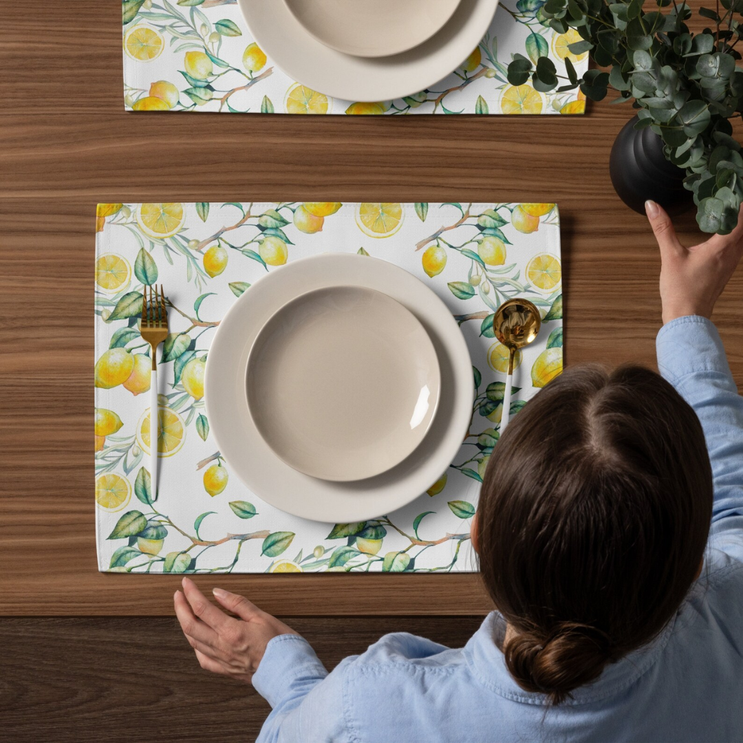 woman set up table dining with lemon placemats from Blue Water Songsand plates 