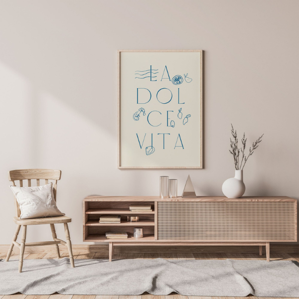 Framed La Dolce Vita text art print styled in a neutral living room with Scandinavian-inspired wooden furniture