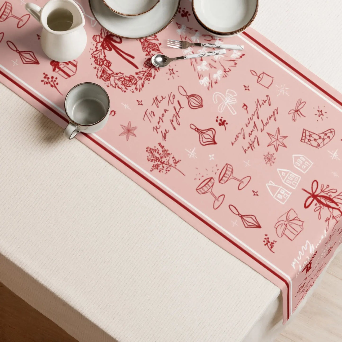 Blush Pink Christmas Table Runner with red line art design, holiday decor on a dining table setting.