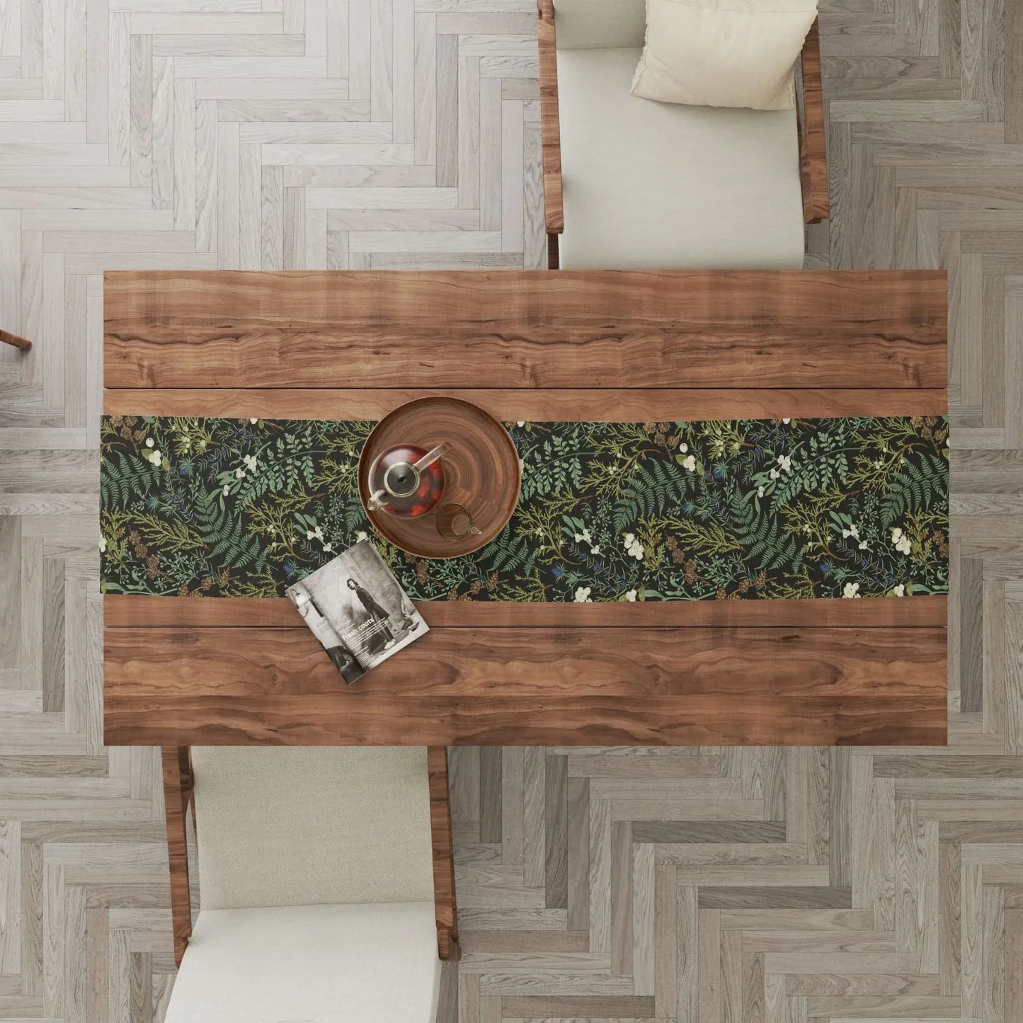 Botanical Christmas table runner on a wooden dining table, featuring soft winter greenery and seasonal florals.