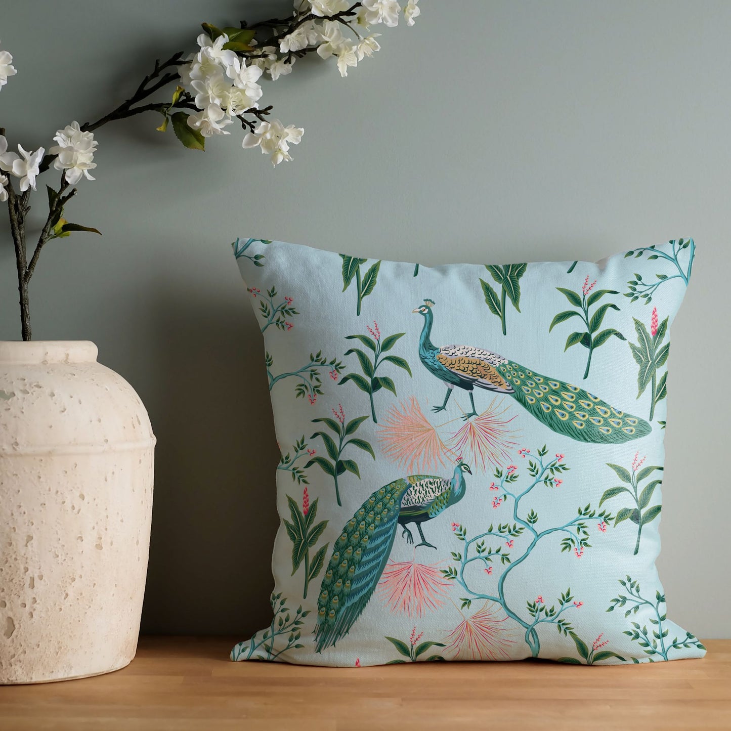 Chinoiserie Blue Peacocks Chinoiserie PILLOW leaning on green wall