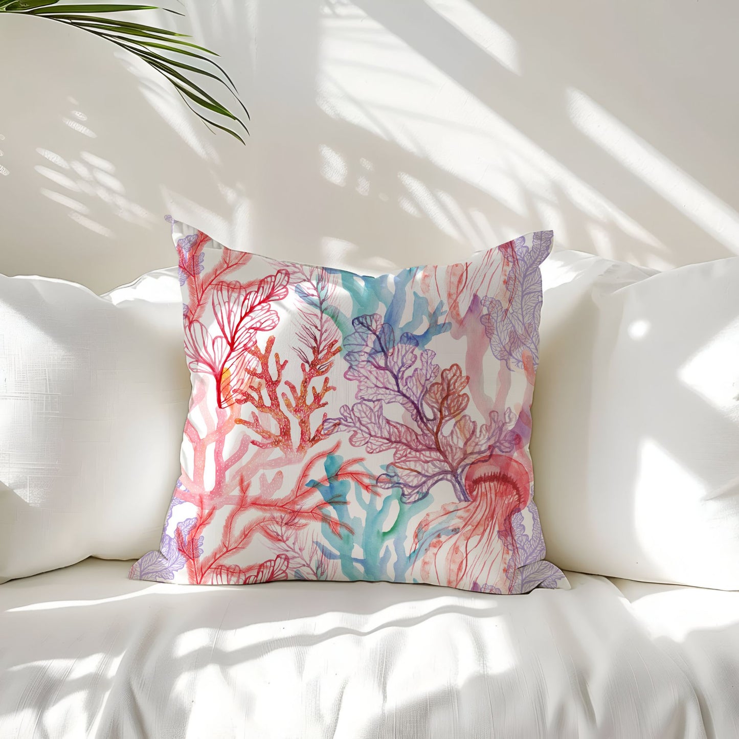 Coral reef pillow on white couch with plant. Ocean-themed decorative pillow with coral and jellyfish design
