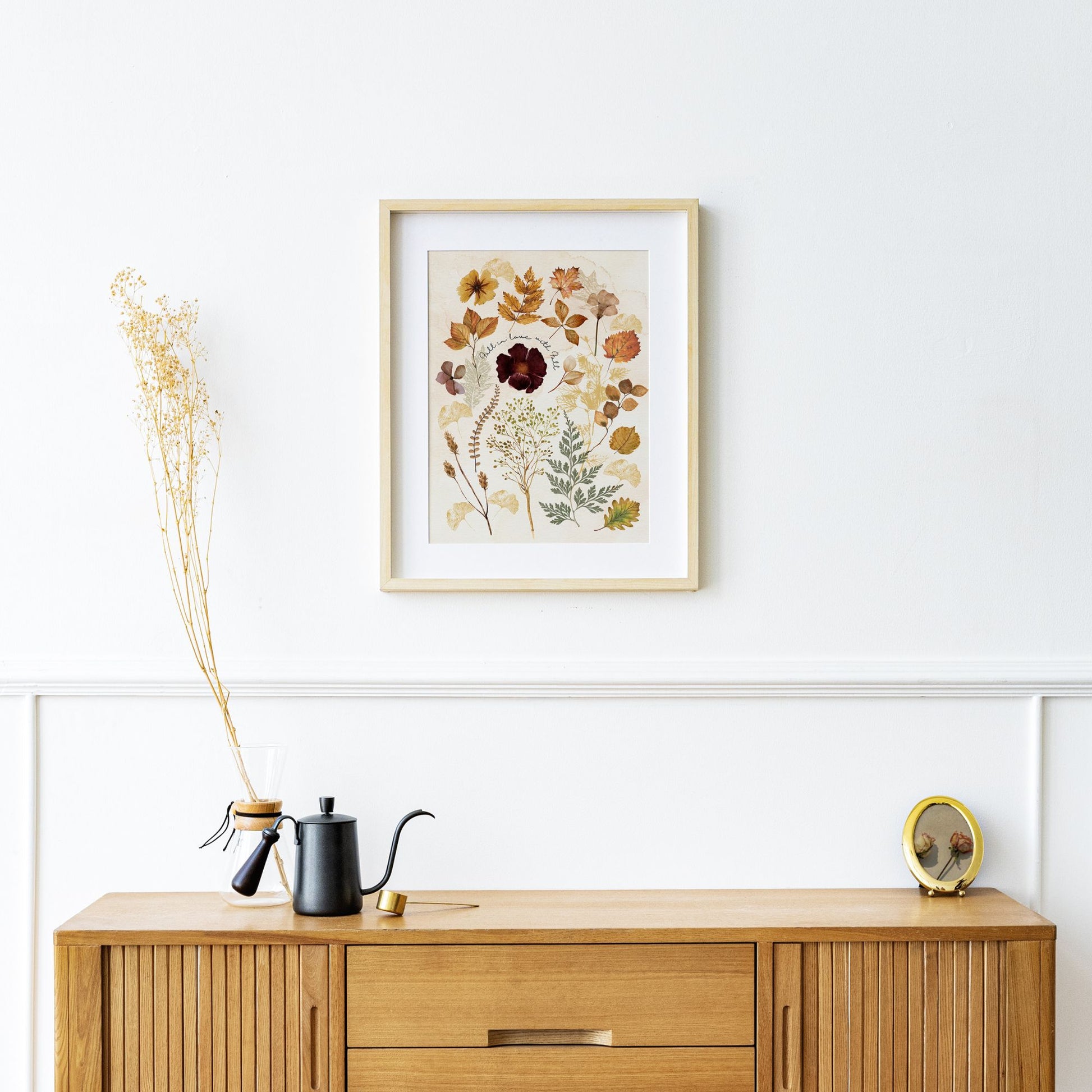 living room with Botanical Fall leaves painting from Blue Water Songs on wall and wood buffet cabinet 