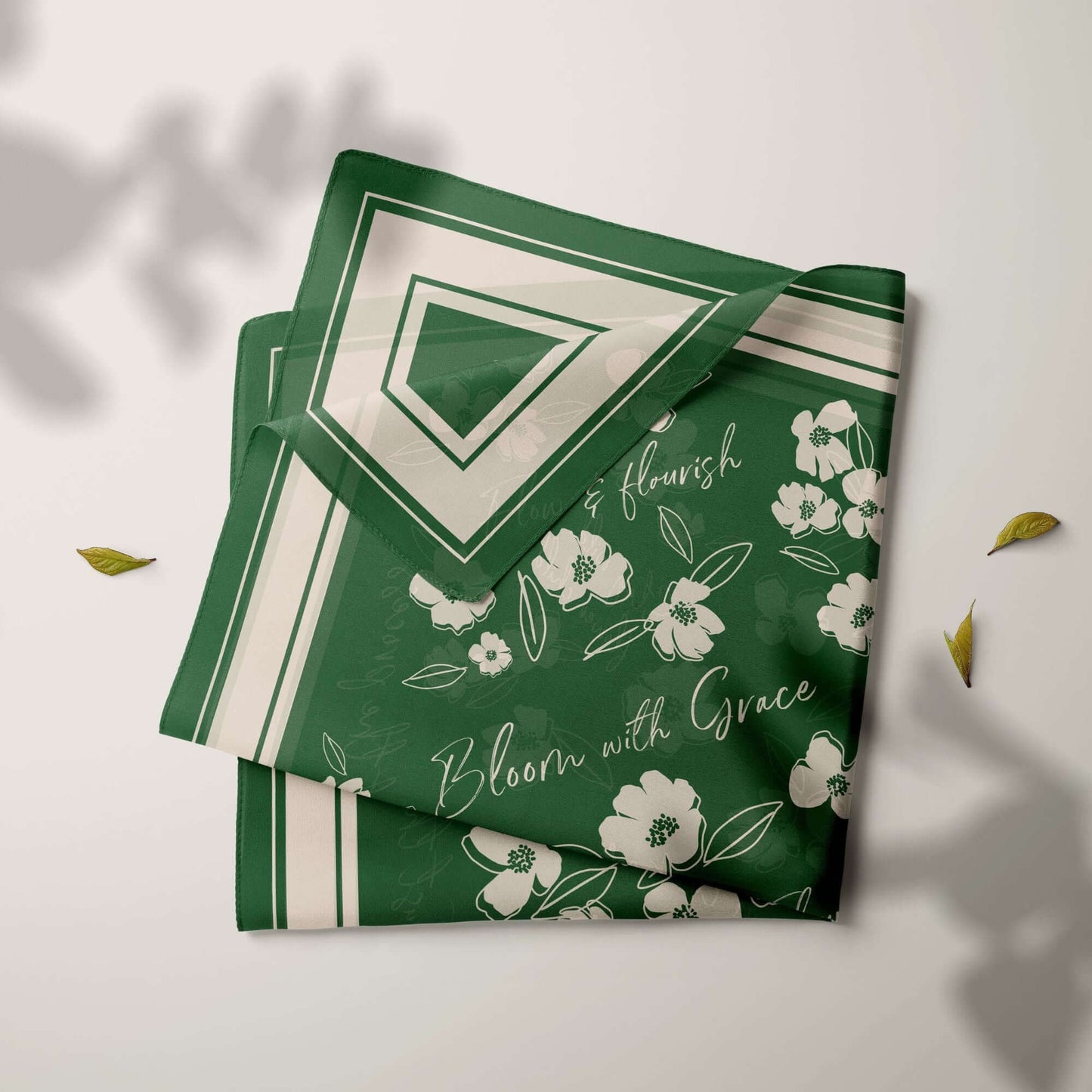 Folded emerald green silk scarf with white wildflowers and the inspirational phrases "flourish" and "Bloom with Grace".