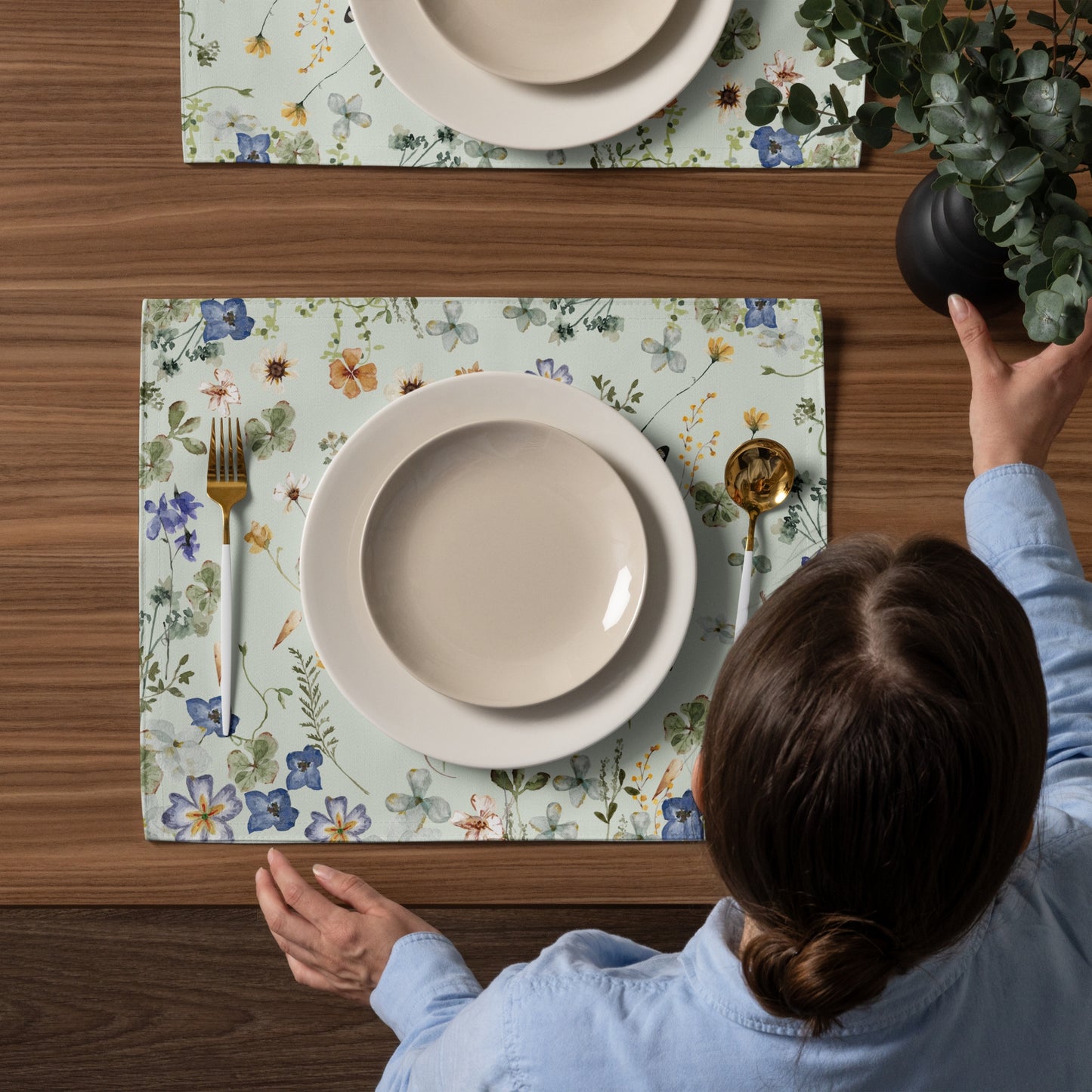 woman arrange table settings with flower placemats and plates