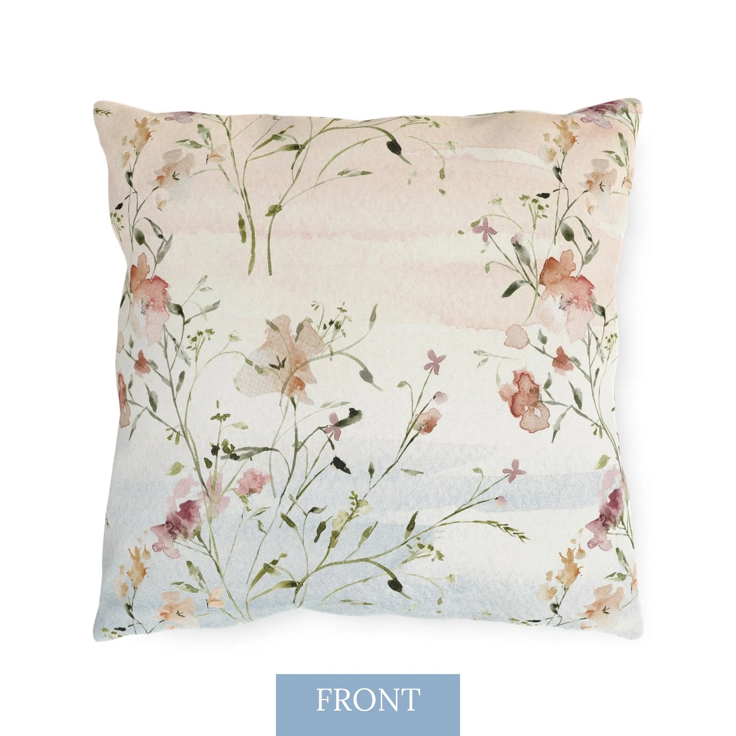 Front view of outdoor pillow with watercolor wildflowers, butterflies, and soft sunrise tones