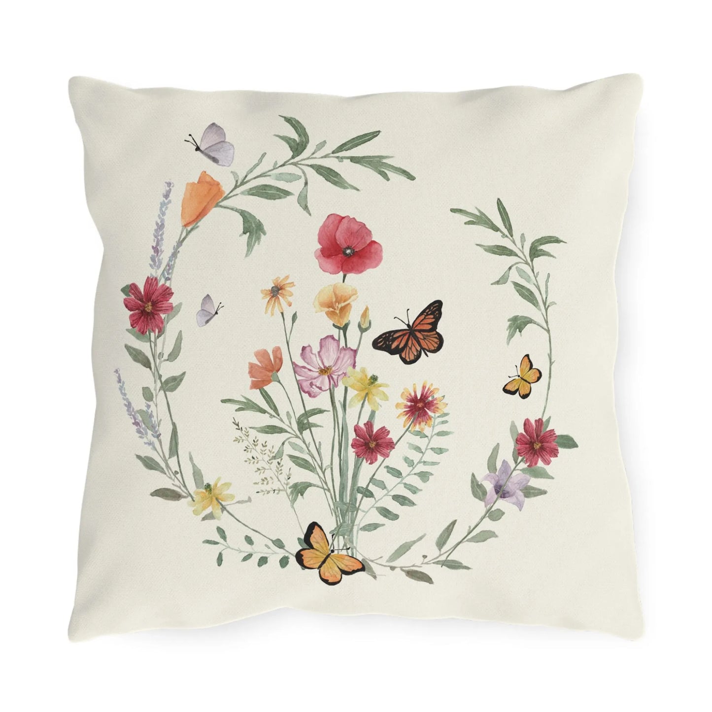 Nature-inspired outdoor pillow with watercolor wildflowers and butterflies in a circular wreath on a warm cream background.