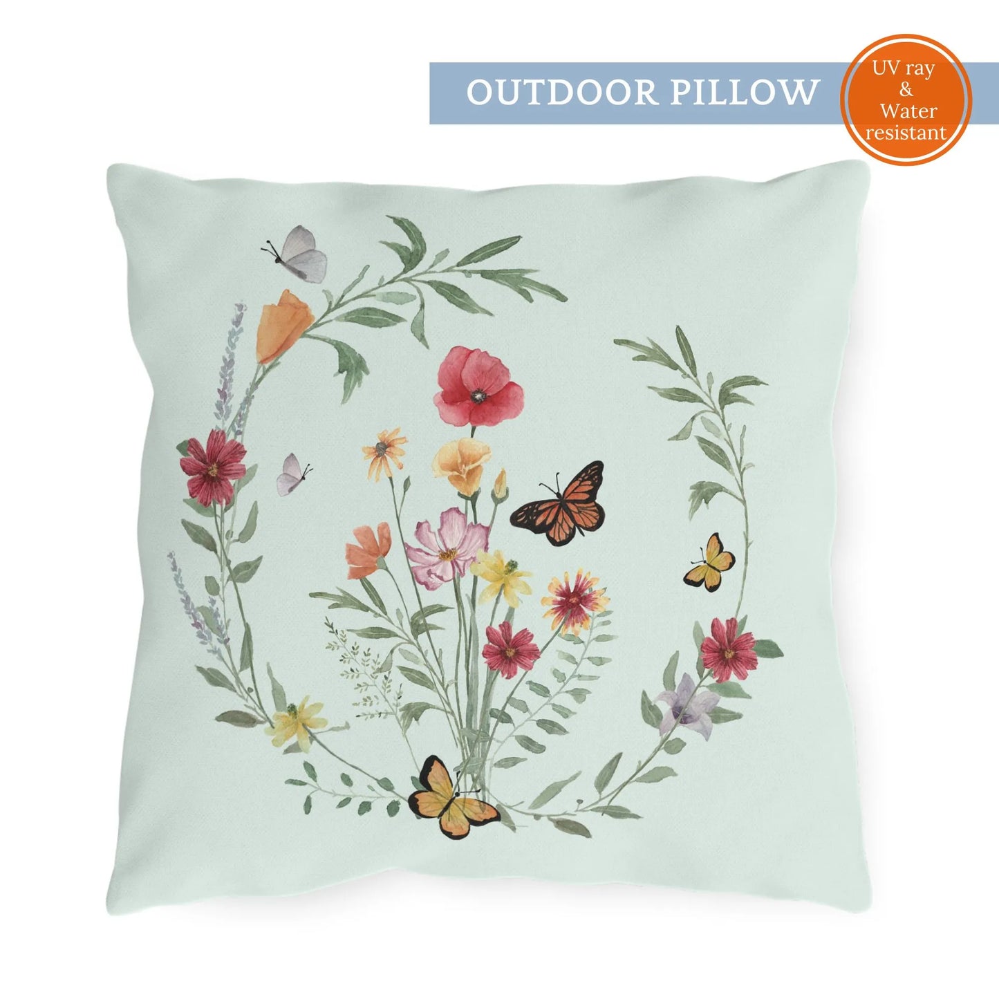 Outdoor pillow featuring a botanical wreath of watercolor wildflowers and butterflies on a pale mint green background.