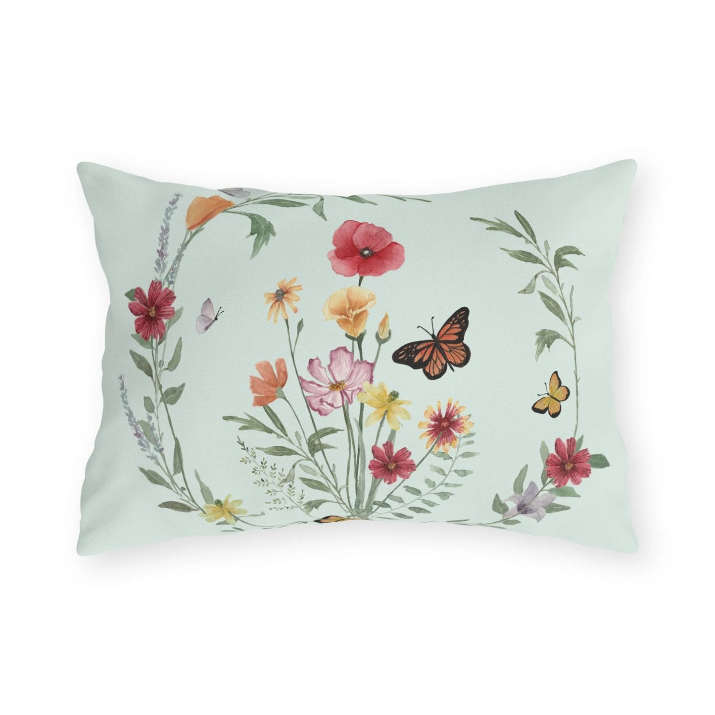 Botanical outdoor lumbar pillow featuring a watercolor wreath of wildflowers and butterflies on a soft mint green background.