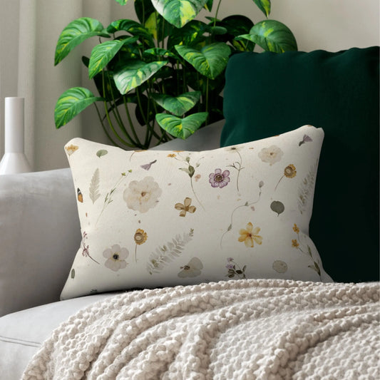 Wildflowers lumbar pillow by Blue Water Songs on a gray sofa with a textured throw. Delicate floral design with butterflies and botanical elements.