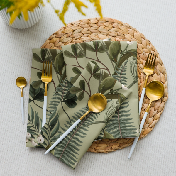 Green Botanical Napkins on the placemat with golden spoons and forks
