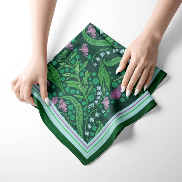 Woman's hands holding Silk SCARF with pattern of Green Lily of the Valley