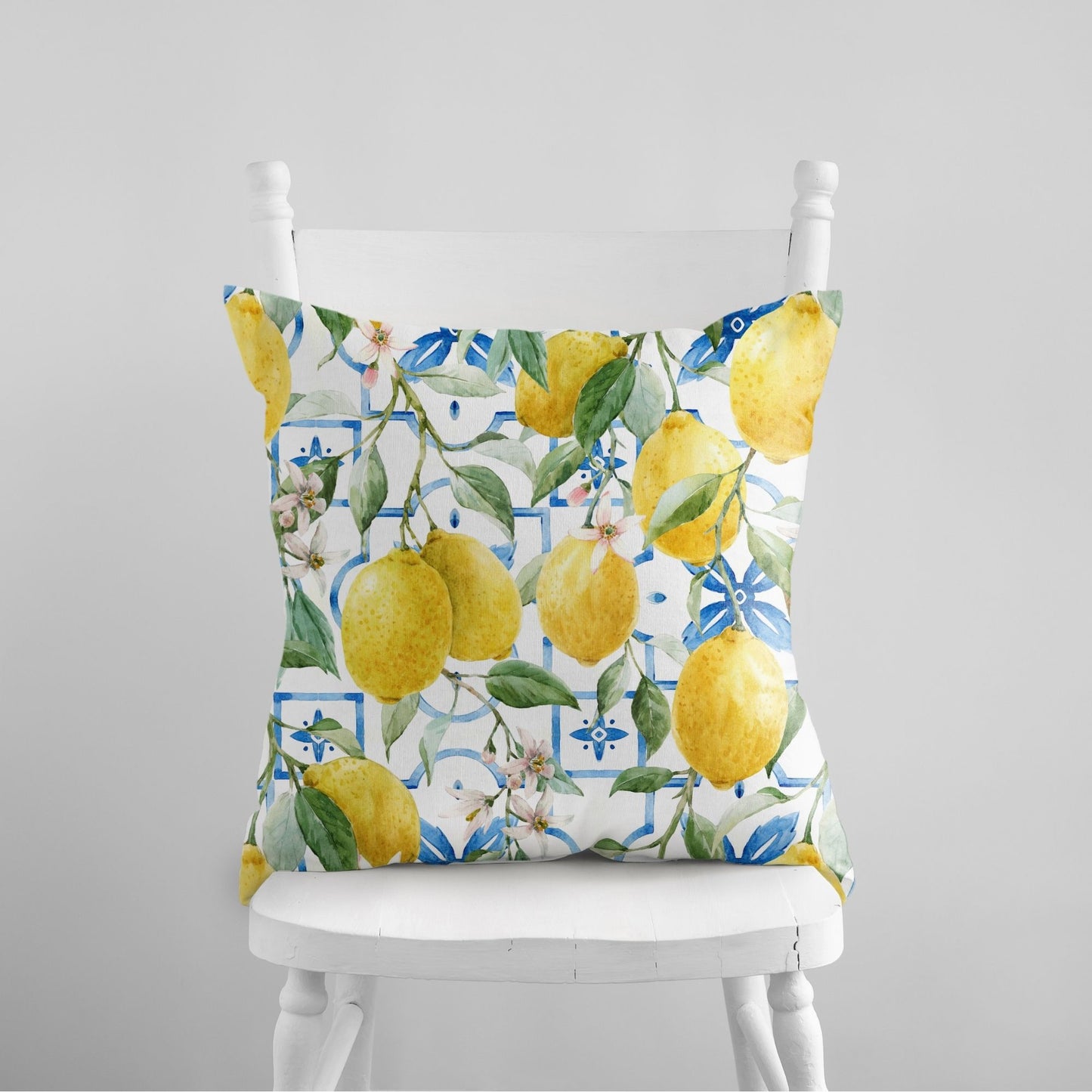 Colorful lemon pillow cover with watercolor lemon design on white chair – summer home decor.