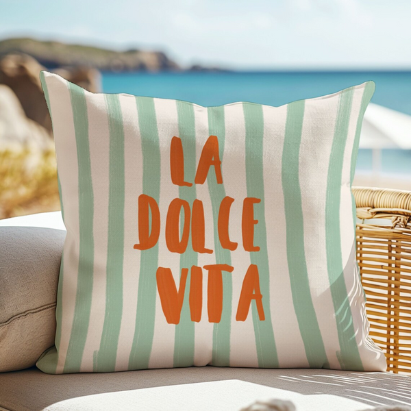 La Dolce Vita Green striped PILLOW from Blue Water Songs on rattan chair with sea view behind