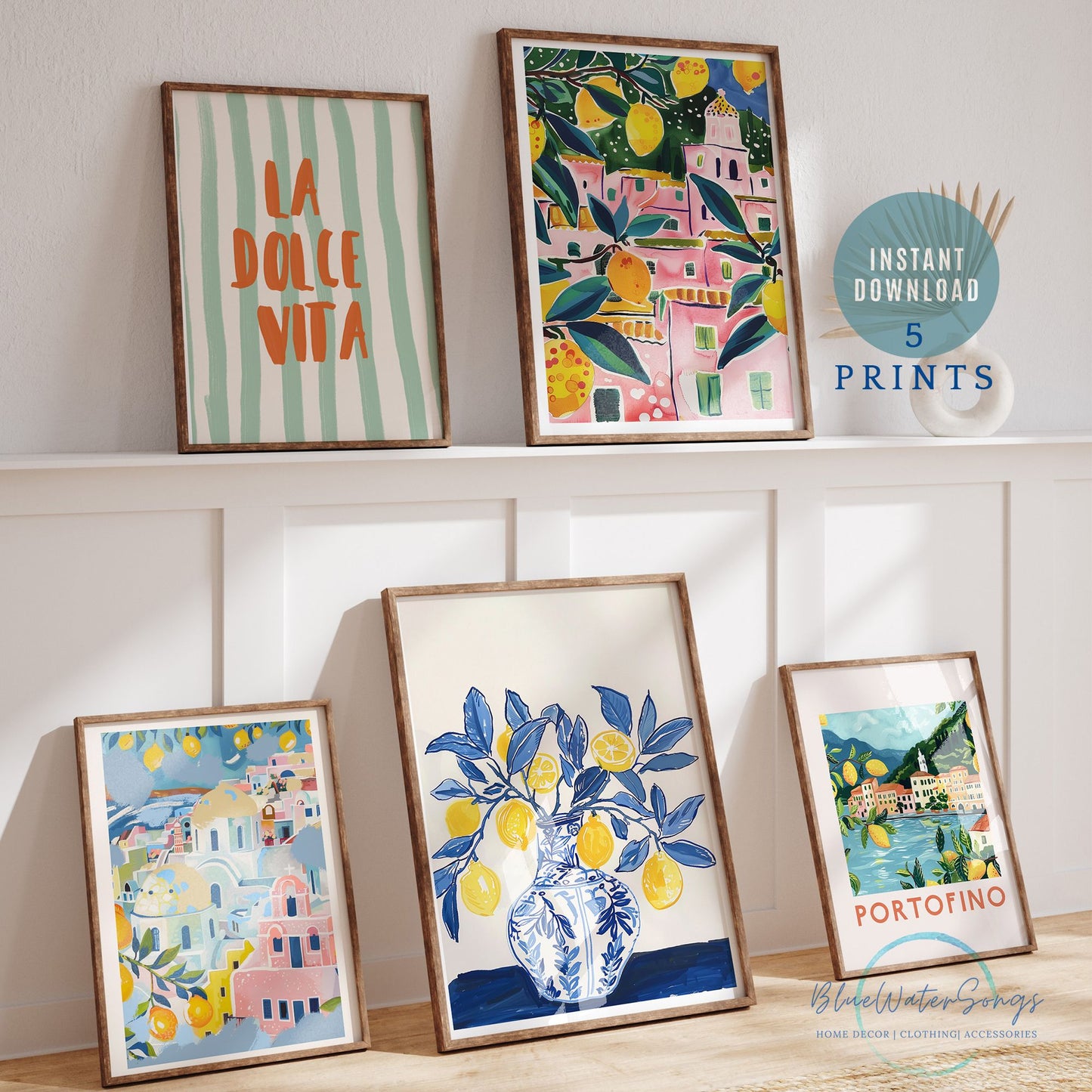 Set of five Mediterranean-style printable art prints styled against a white wall with lemon, villa, and Portofino illustrations