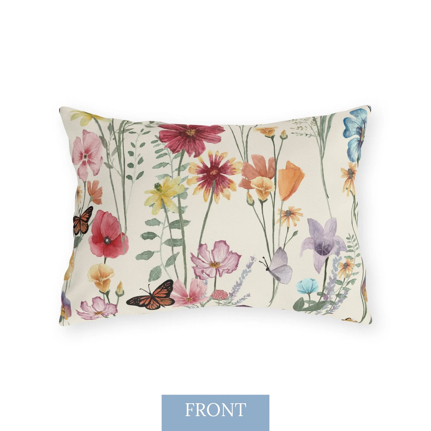 Front view of a rectangular outdoor pillow with a colorful watercolor wildflower and butterfly pattern on a cream background.