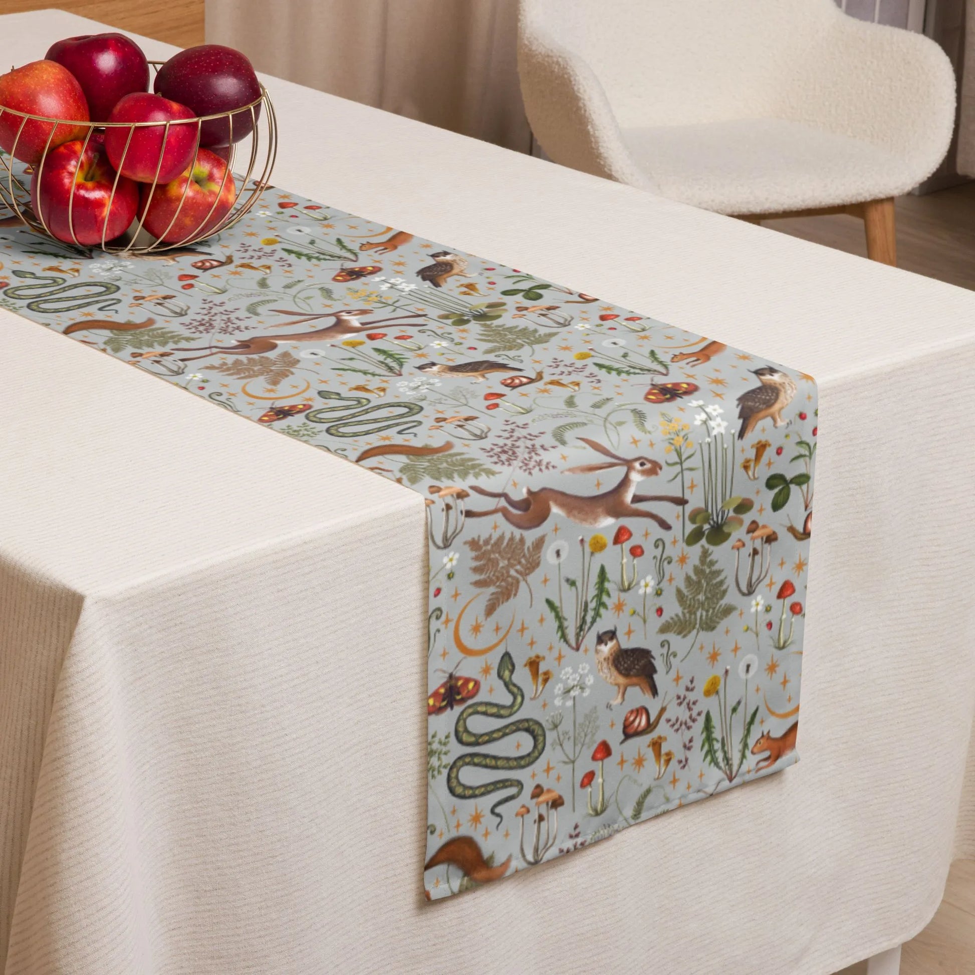 white dining table with apples and Magic forest TABLE RUNNER from Blue Water Songs on it