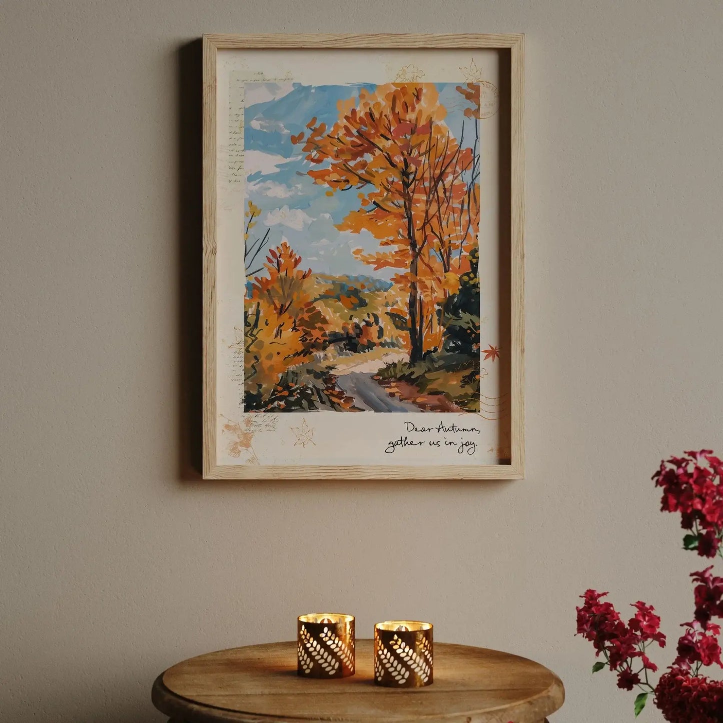 Framed autumnal wall art “Autumn Road” print with golden trees, styled on wall above candles and red flowers