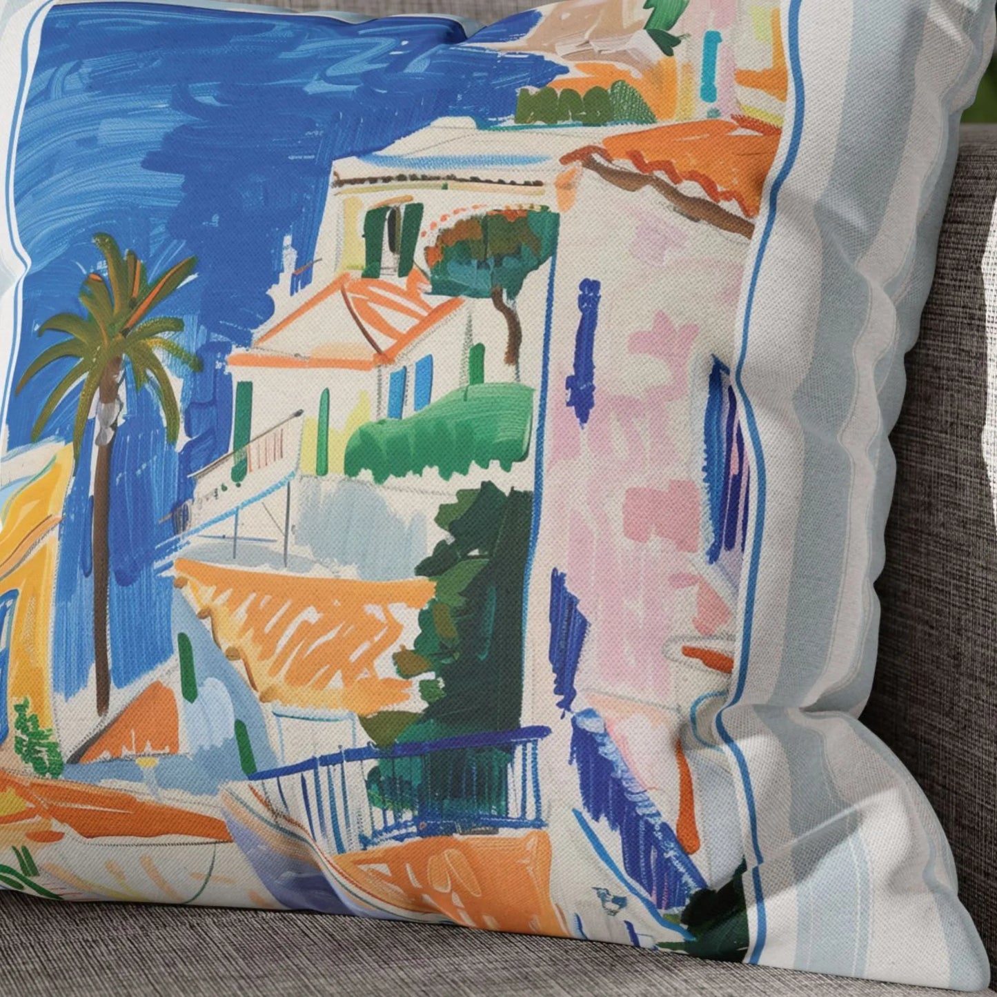 Close-up of Mediterranean coastal pillow cover with painted seaside village and palm tree in vivid colors