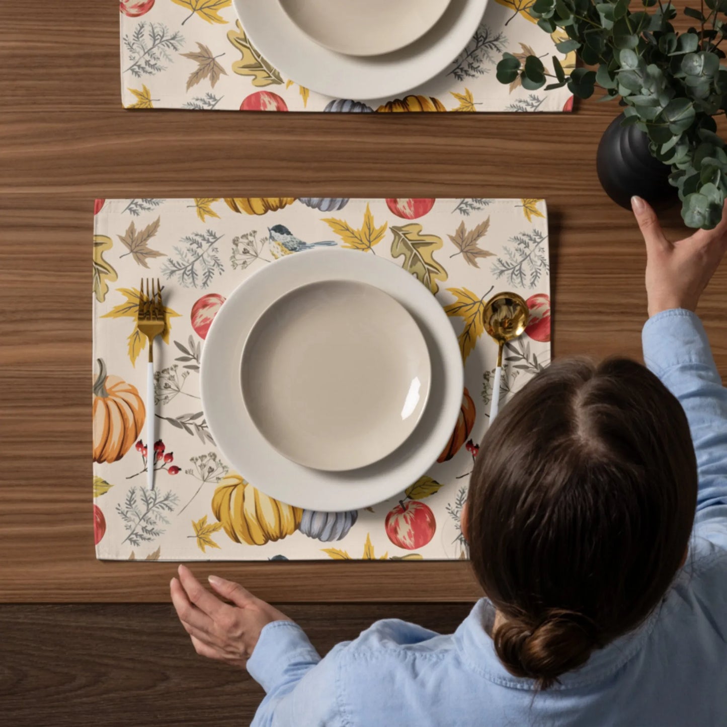 woman setting up thanksgiving dining table with Pumpkin and bird PLACEMATS from Blue Water Songs