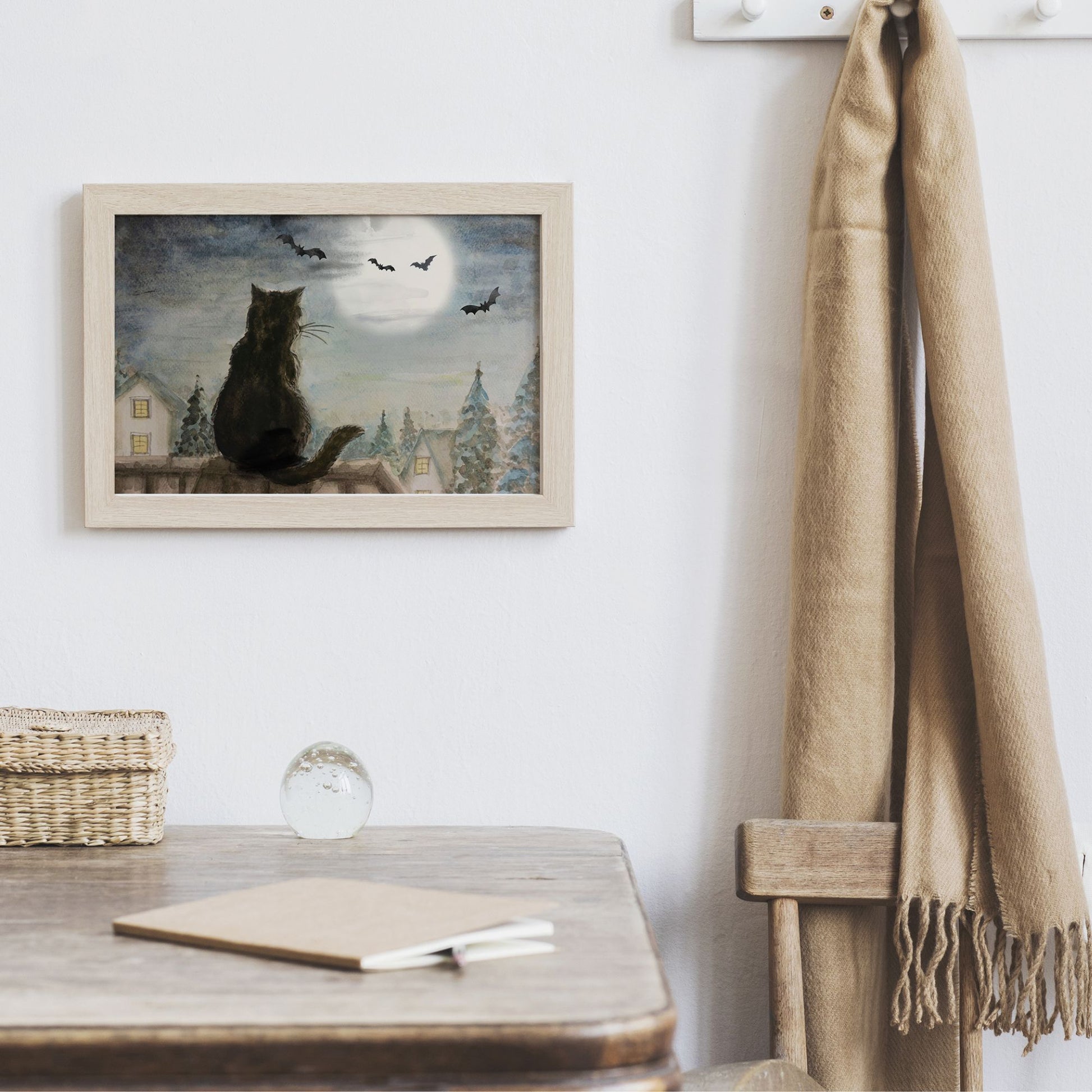 Black cat on roof top halloween Art Print hanging on wall next to brown scarf