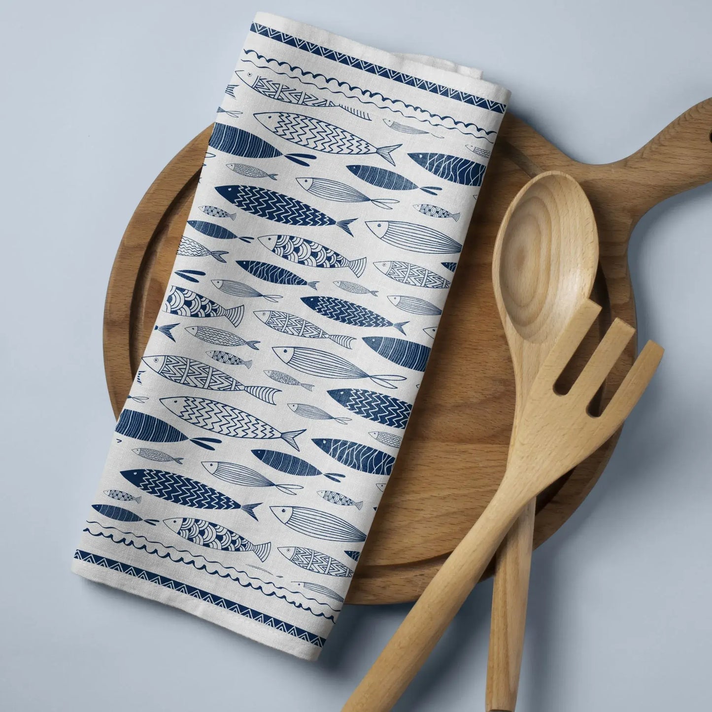Blue Fish Coastal Cloth Napkins – Nautical Table Linen folded on a wooden platter with utensils.