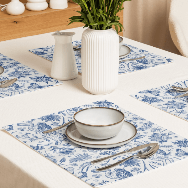 Blue Toile Bunny Placemats styled on a dining table with elegant dishware and a plant centerpiece.