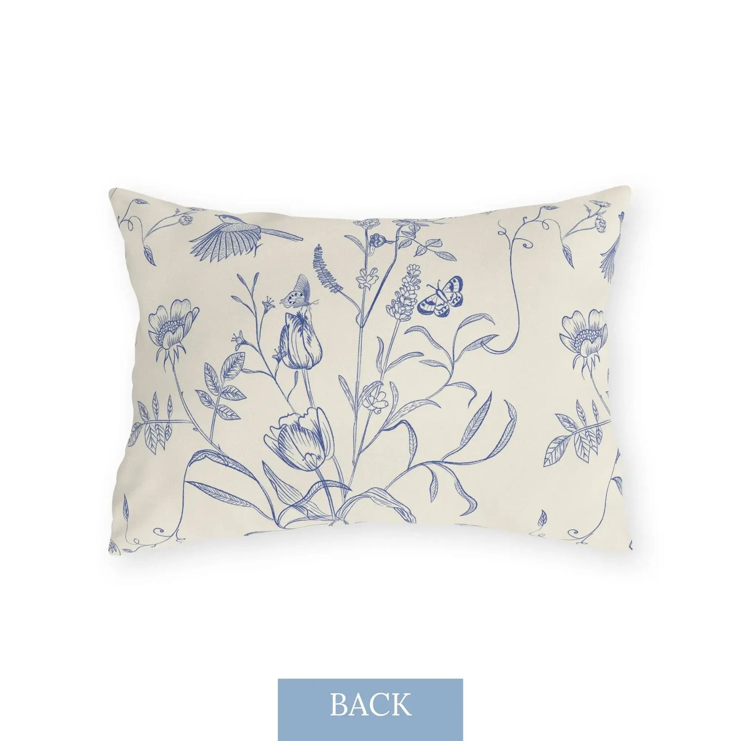 Back view of rectangular outdoor pillow featuring whimsical blue floral illustrations with butterflies, birds, and a tiny forest fairy on cream fabric — nature-inspired patio pillow.