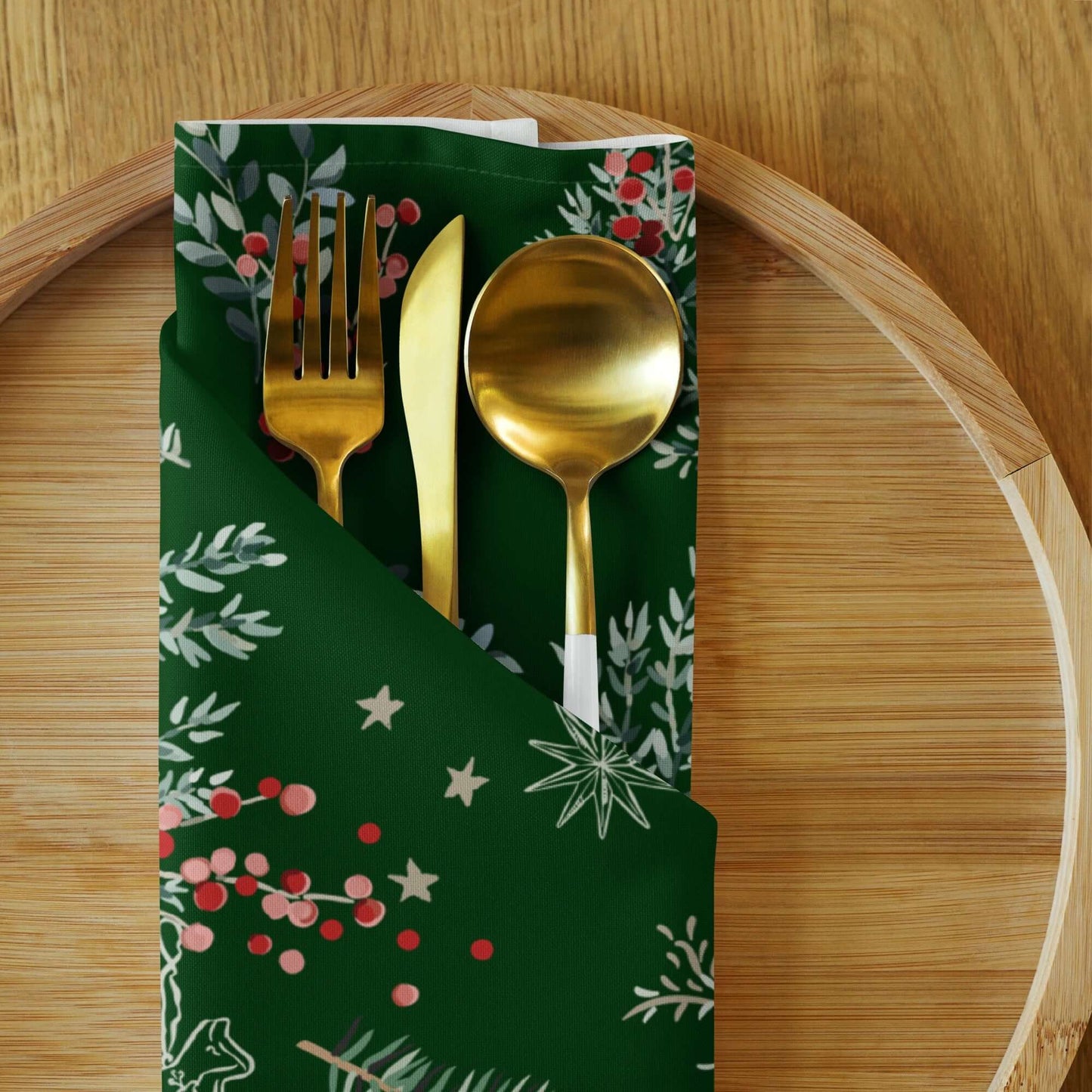 Botanical Christmas Cloth Napkins wrapped around golden utensils on a wooden plate, perfect for holiday table decor.