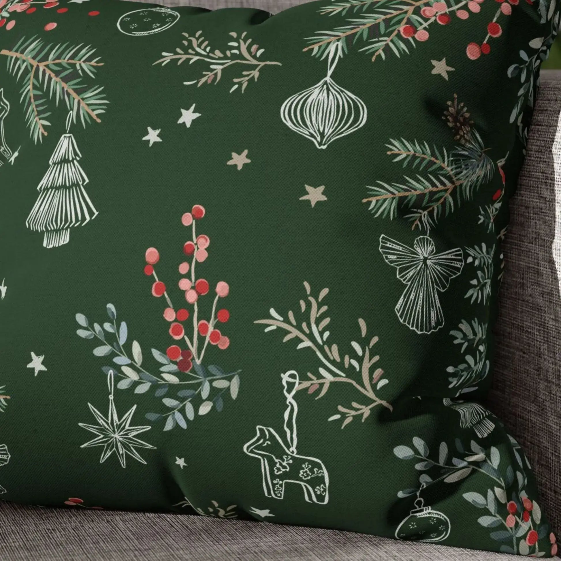 Botanical Christmas pillow cover with pine branches, red berries, and winter greenery in green fabric.