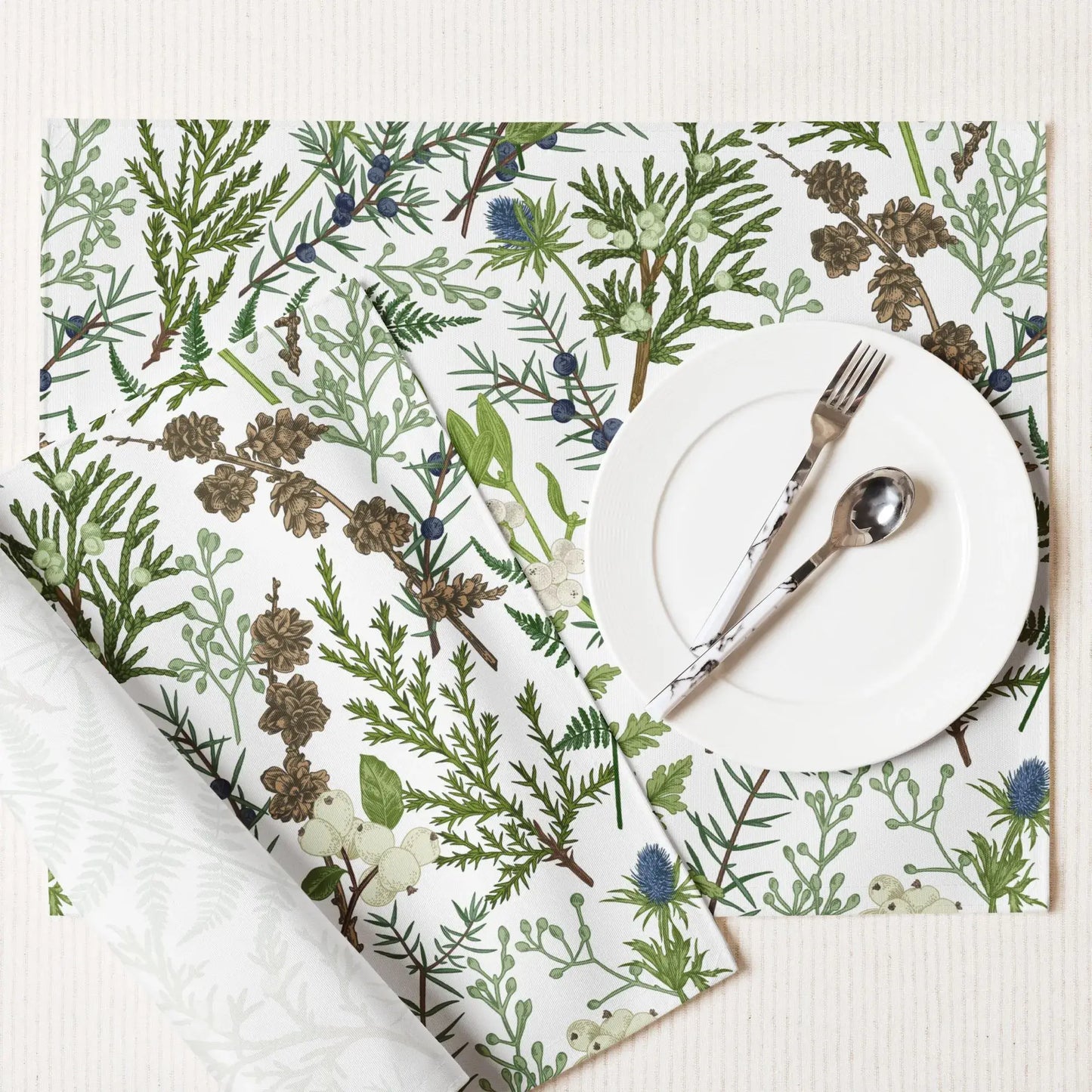 Botanical Christmas placemats featuring soft winter greenery and florals set on a festive dining table.