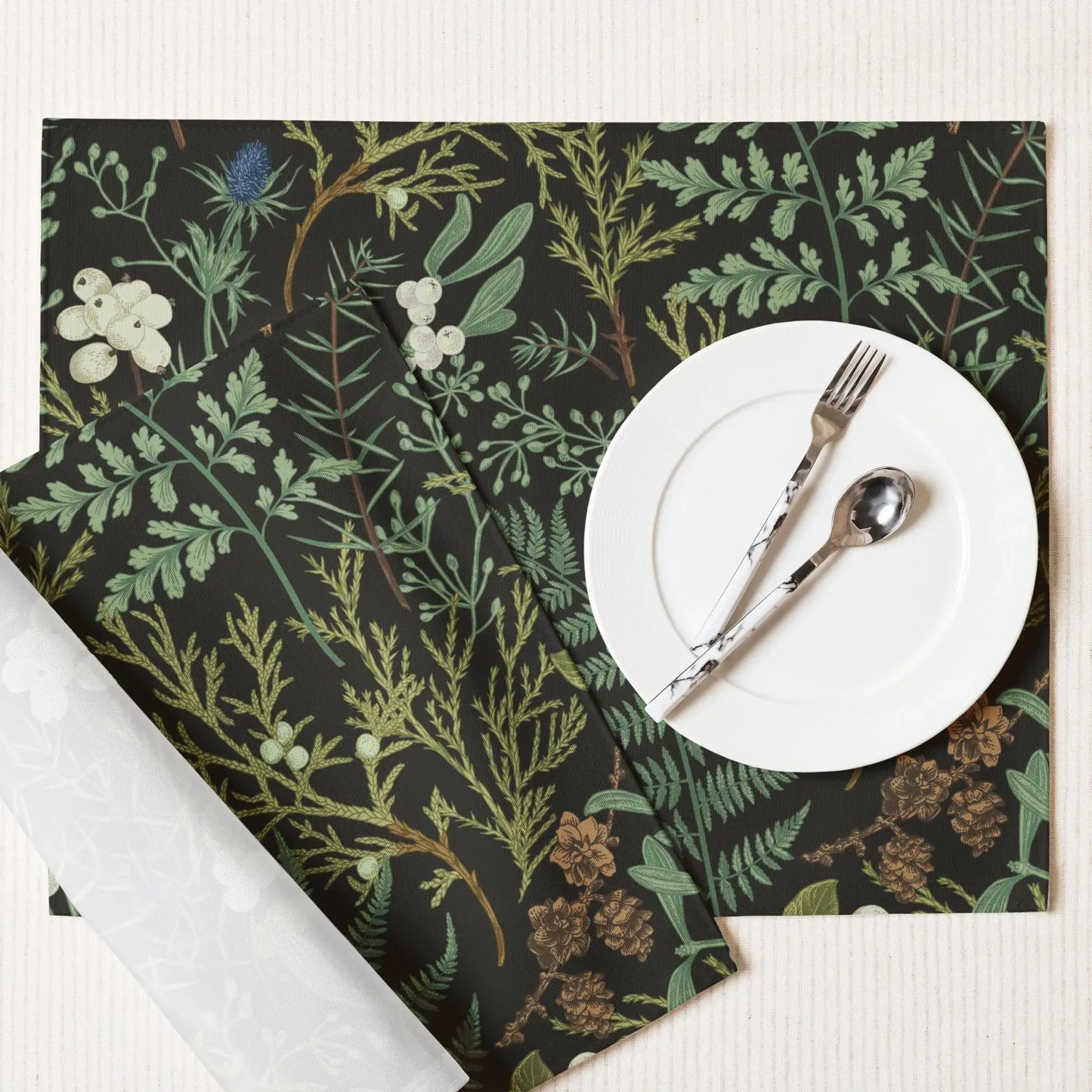 Botanical Christmas placemats featuring soft winter greenery and seasonal florals, styled with neutral dinnerware.