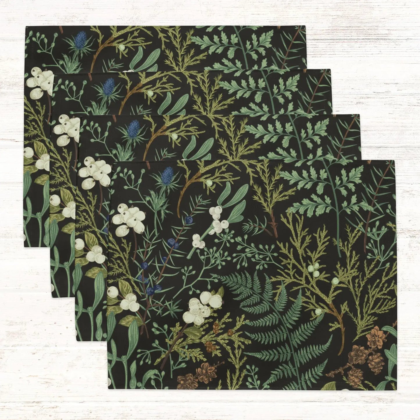 Botanical Christmas placemats featuring winter greenery and florals on a dark background for holiday table decor.