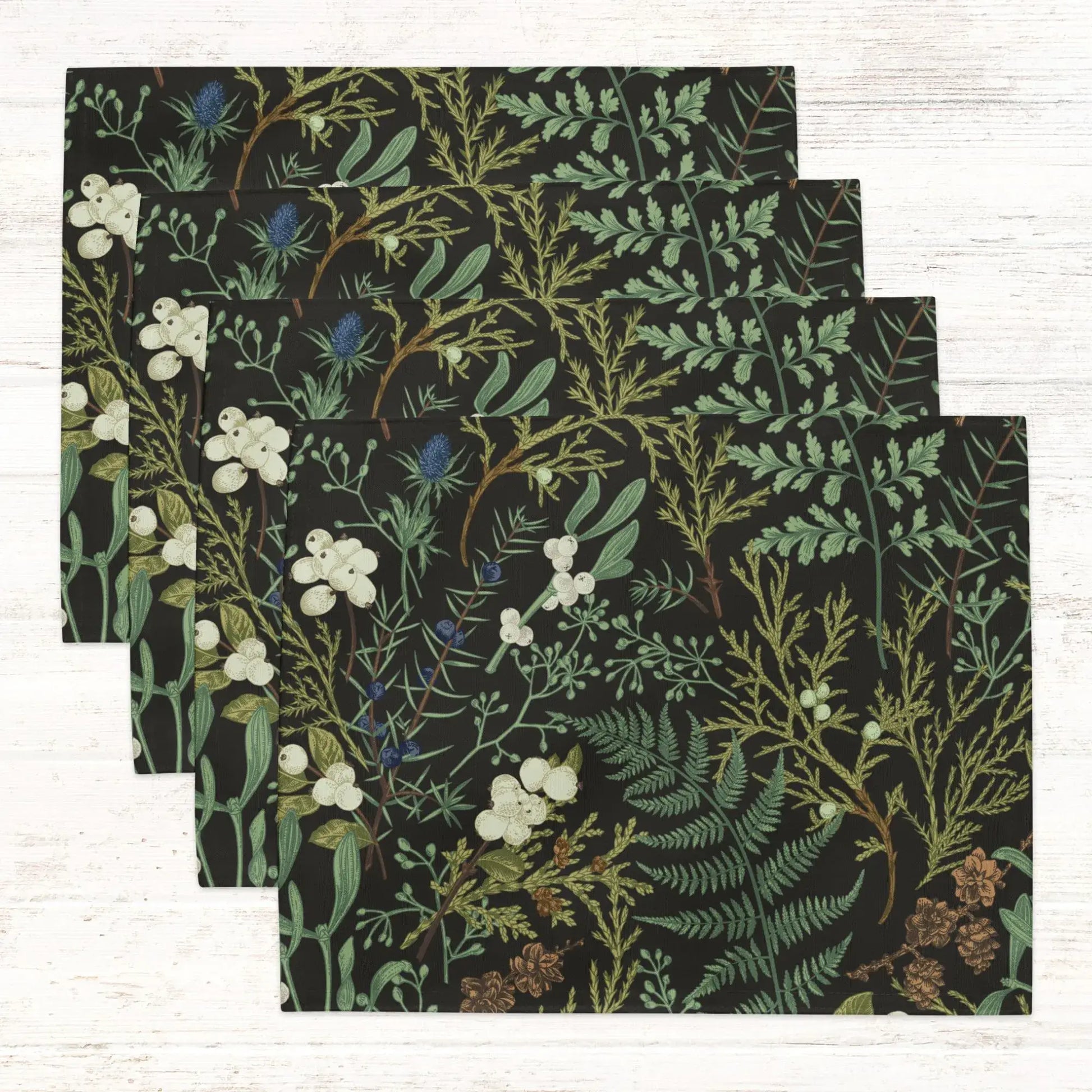 Botanical Christmas placemats featuring winter greenery and florals on a dark background for holiday table decor.