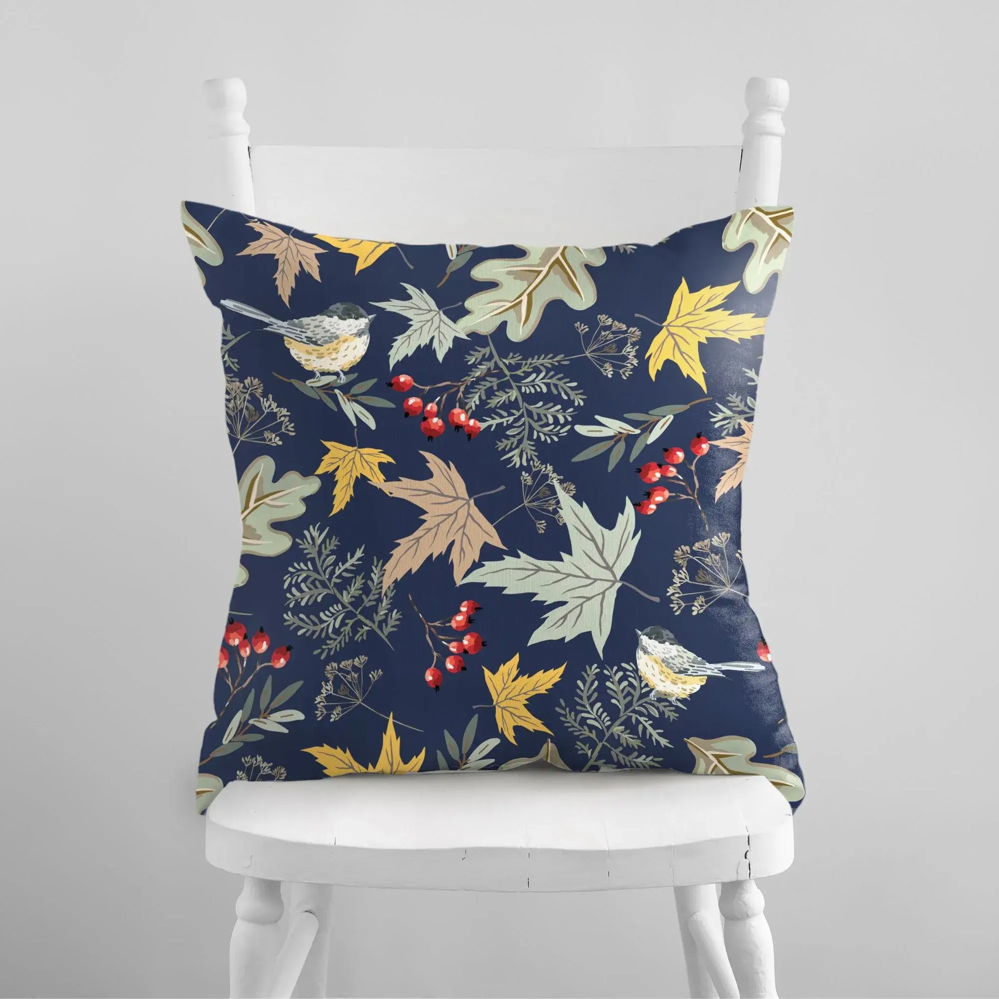 Botanical fall pillow featuring birds and autumn florals on a deep blue background, enhancing cozy interiors.