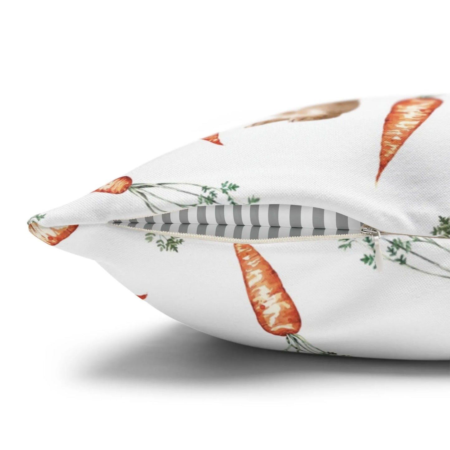 Side view of a watercolor bunny and carrot pillow showing the zipper closure detail on the white fabric.