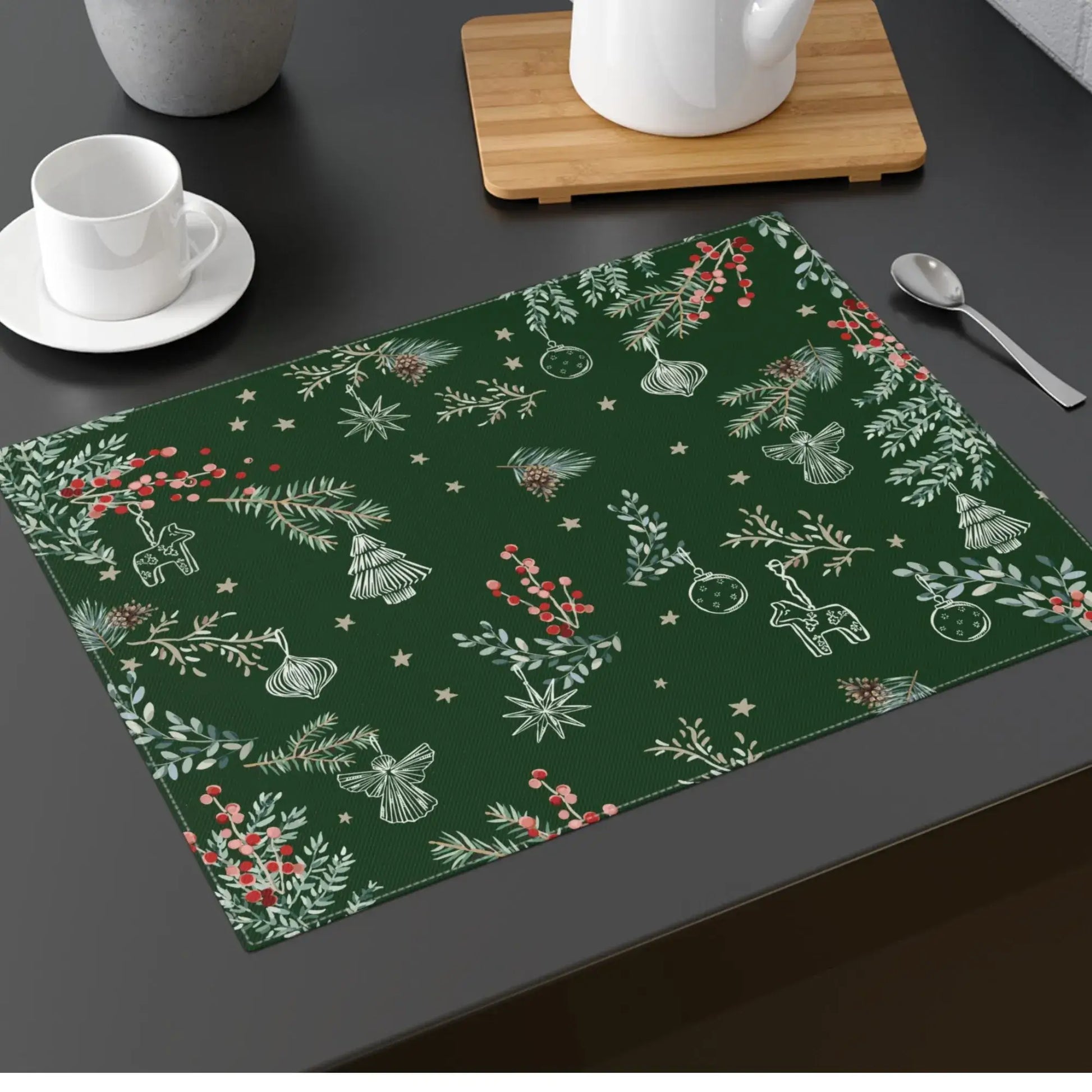 Green Botanical Christmas Placemat with pine and berry print styled on dark holiday table.