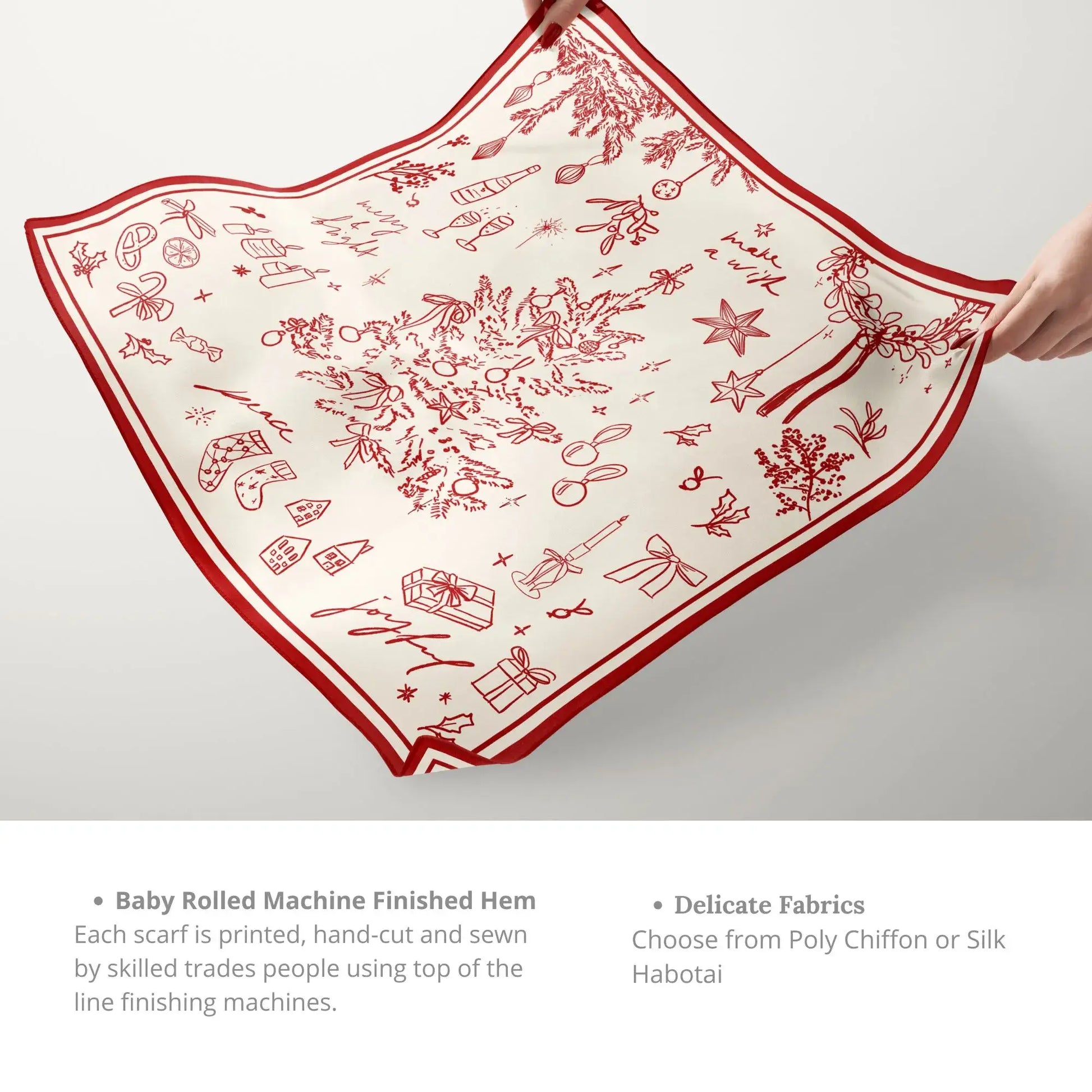 Hands holding red Christmas Silk Scarf ‘Make a Wish’ with festive hand-drawn holiday illustrations and rolled hem finish