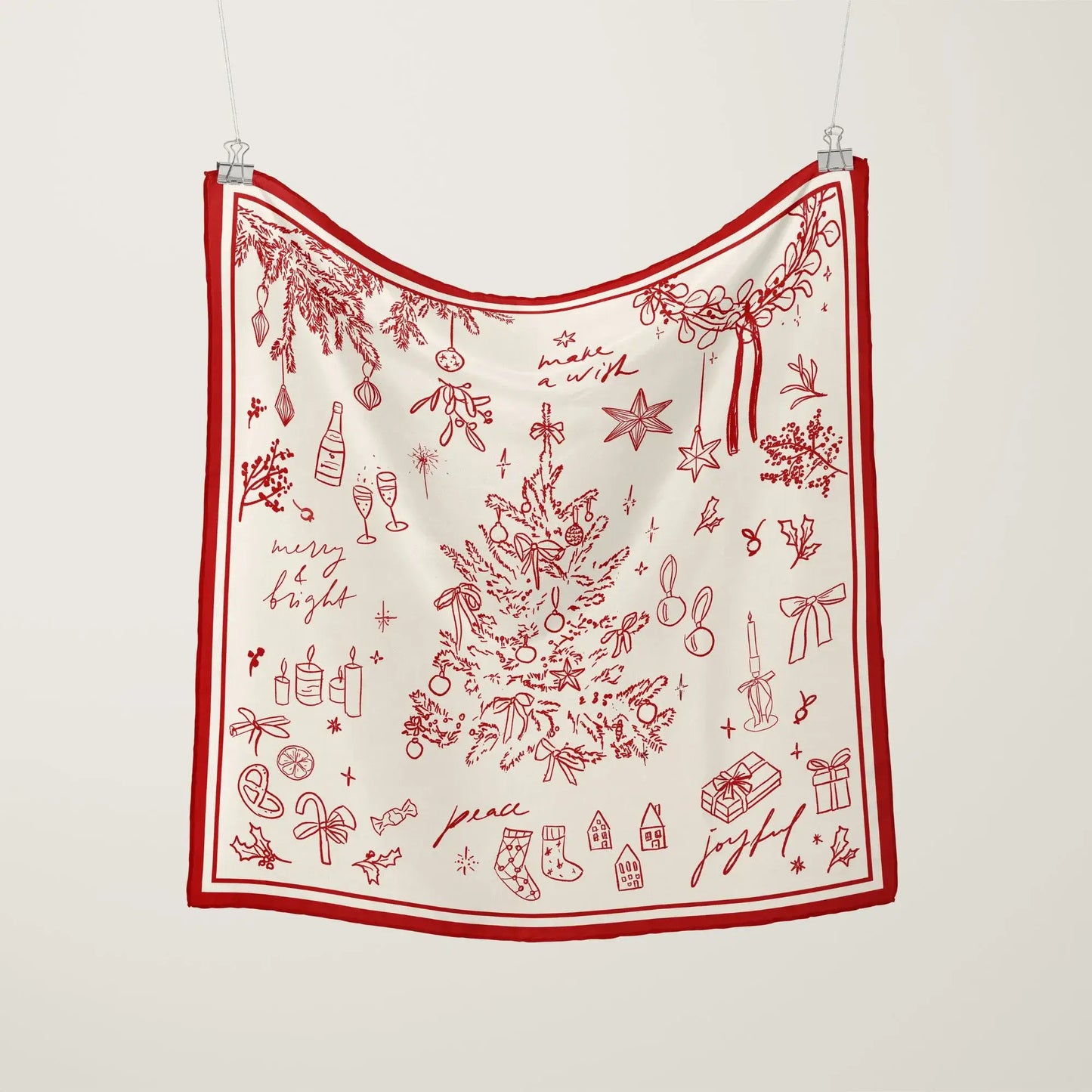 Christmas Silk Scarf “Make a Wish” in red line art with festive holiday illustrations hanging on display.