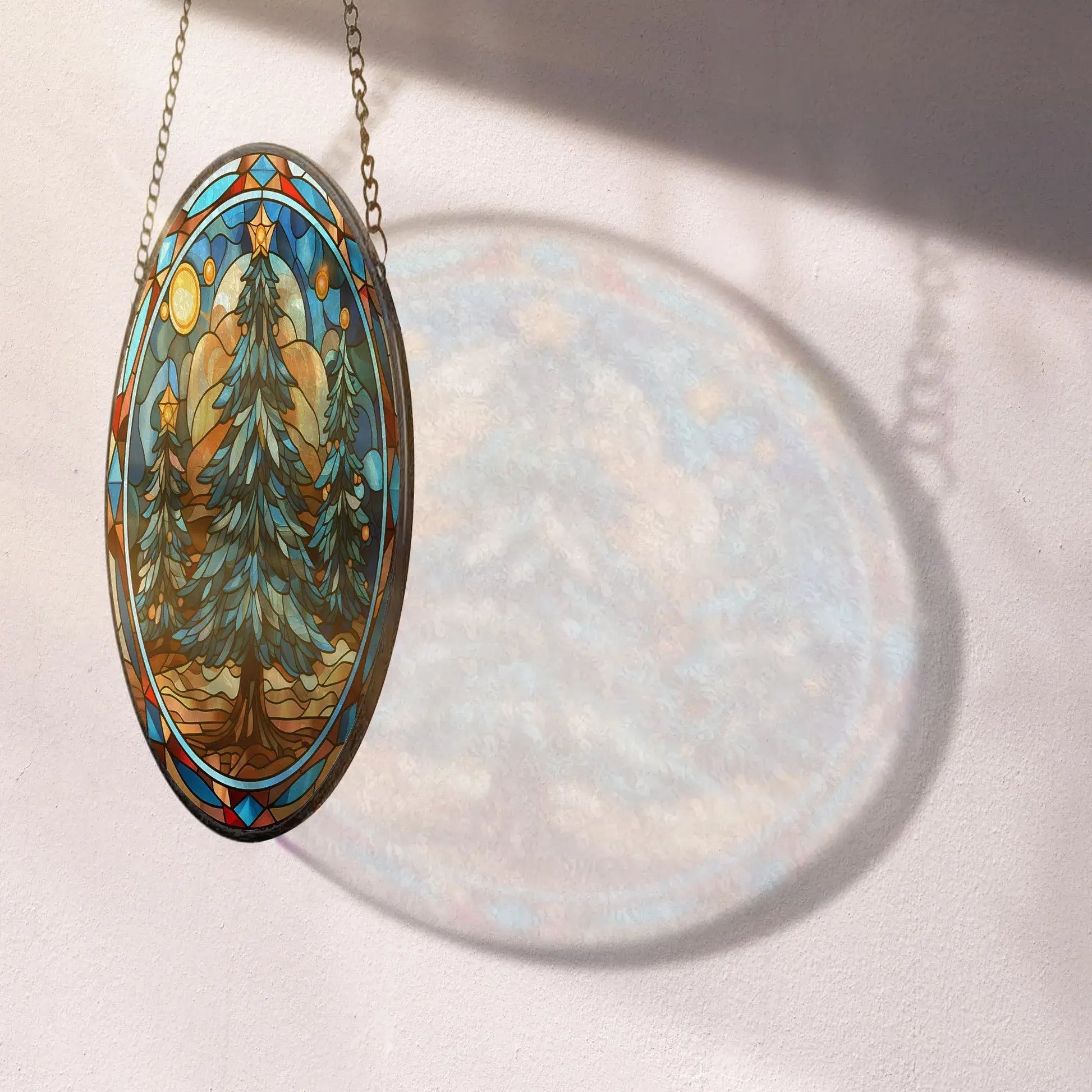 Christmas tree stained glass ornament casting a beautiful shadow on a wall, showcasing its vibrant colors and winter scene.