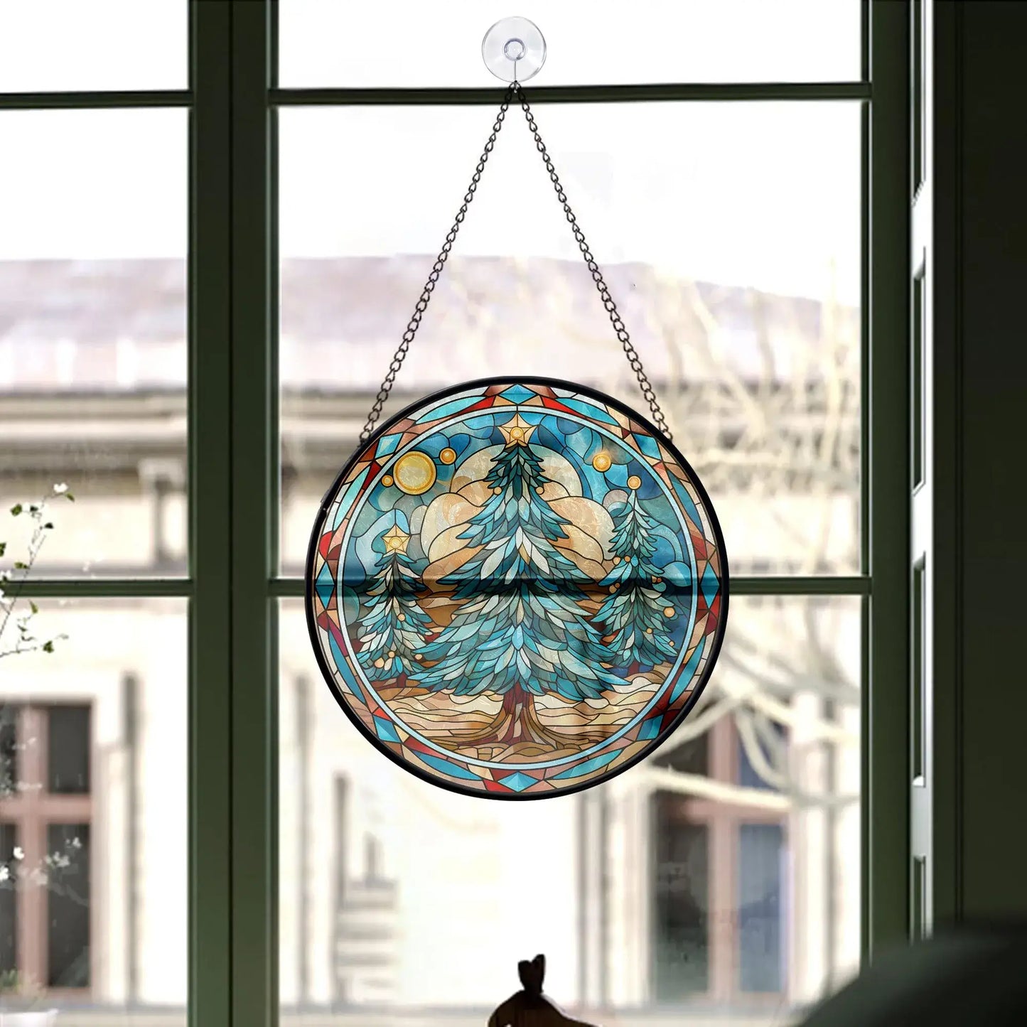 Christmas tree stained glass ornament hanging in a window showcasing blue tones and festive design.