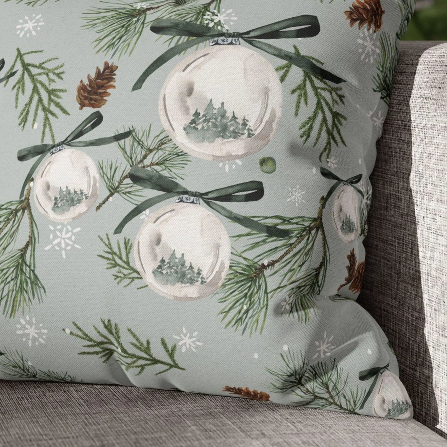 Close-up of Christmas pillow with pine ornament watercolor print – forest green and snowflake details on fabric