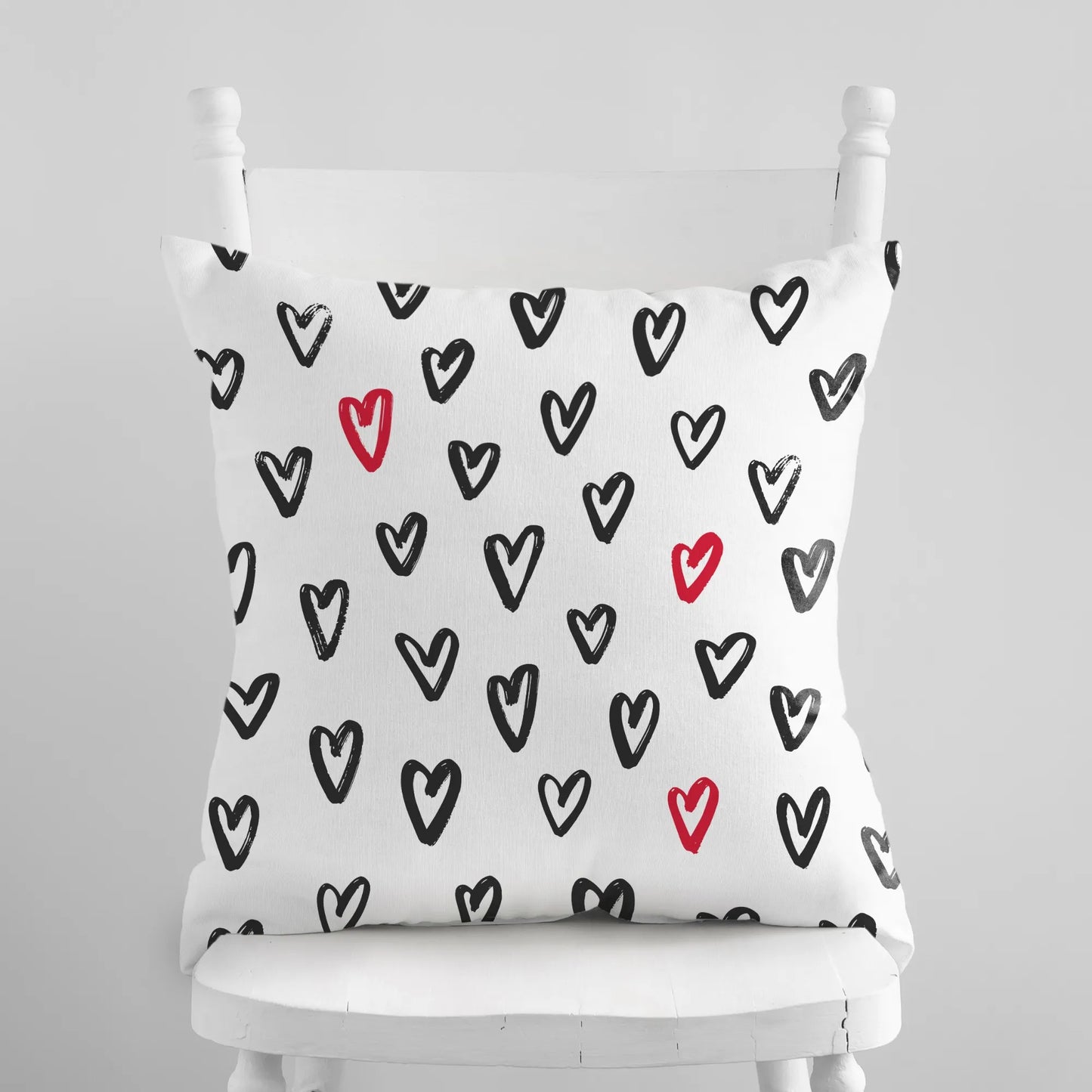 Cute hand-drawn hearts valentine pillow featuring black and red hearts on a white background.